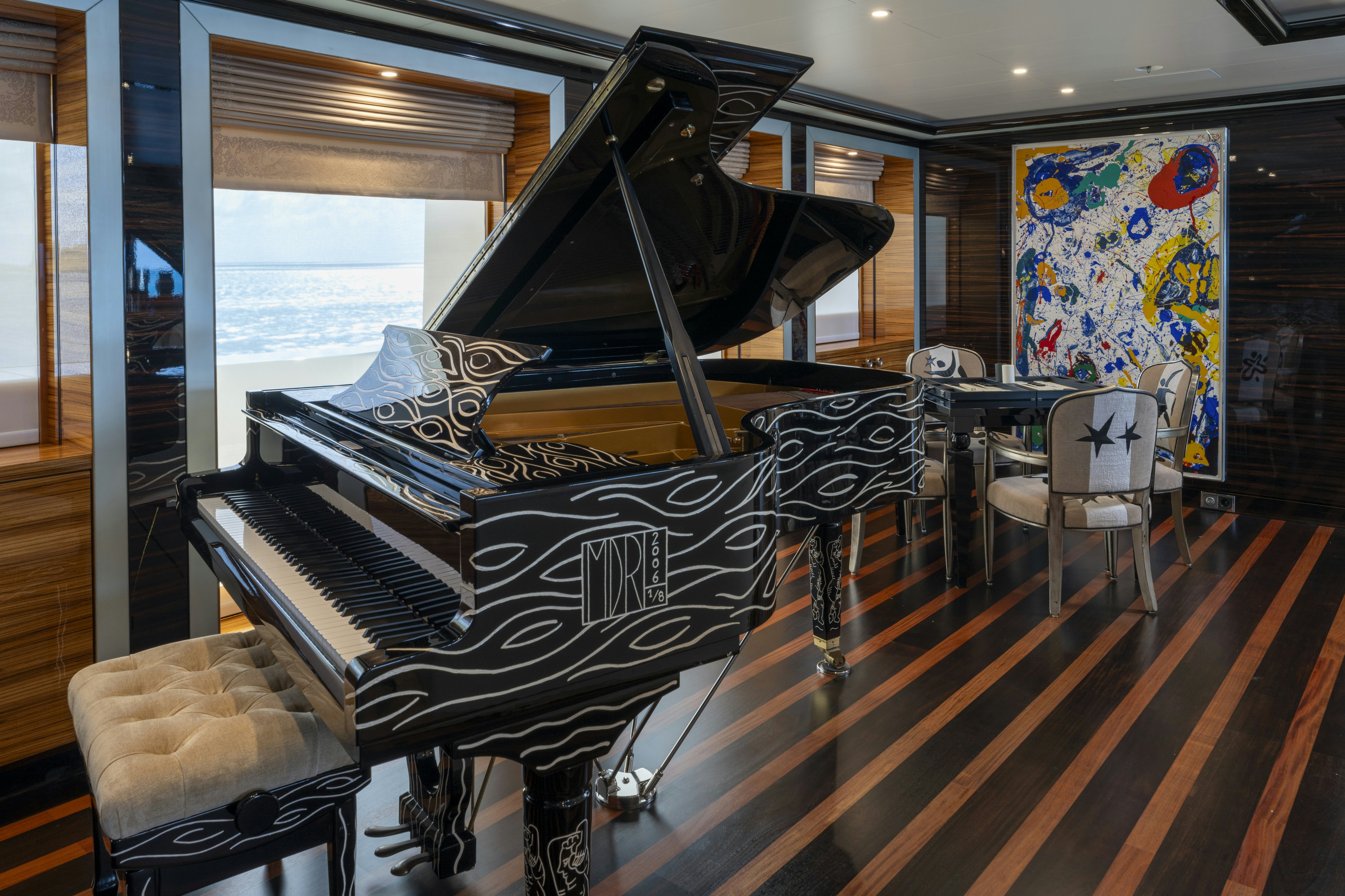 a black grand piano in a room aboard ALFA NERO Yacht for Charter