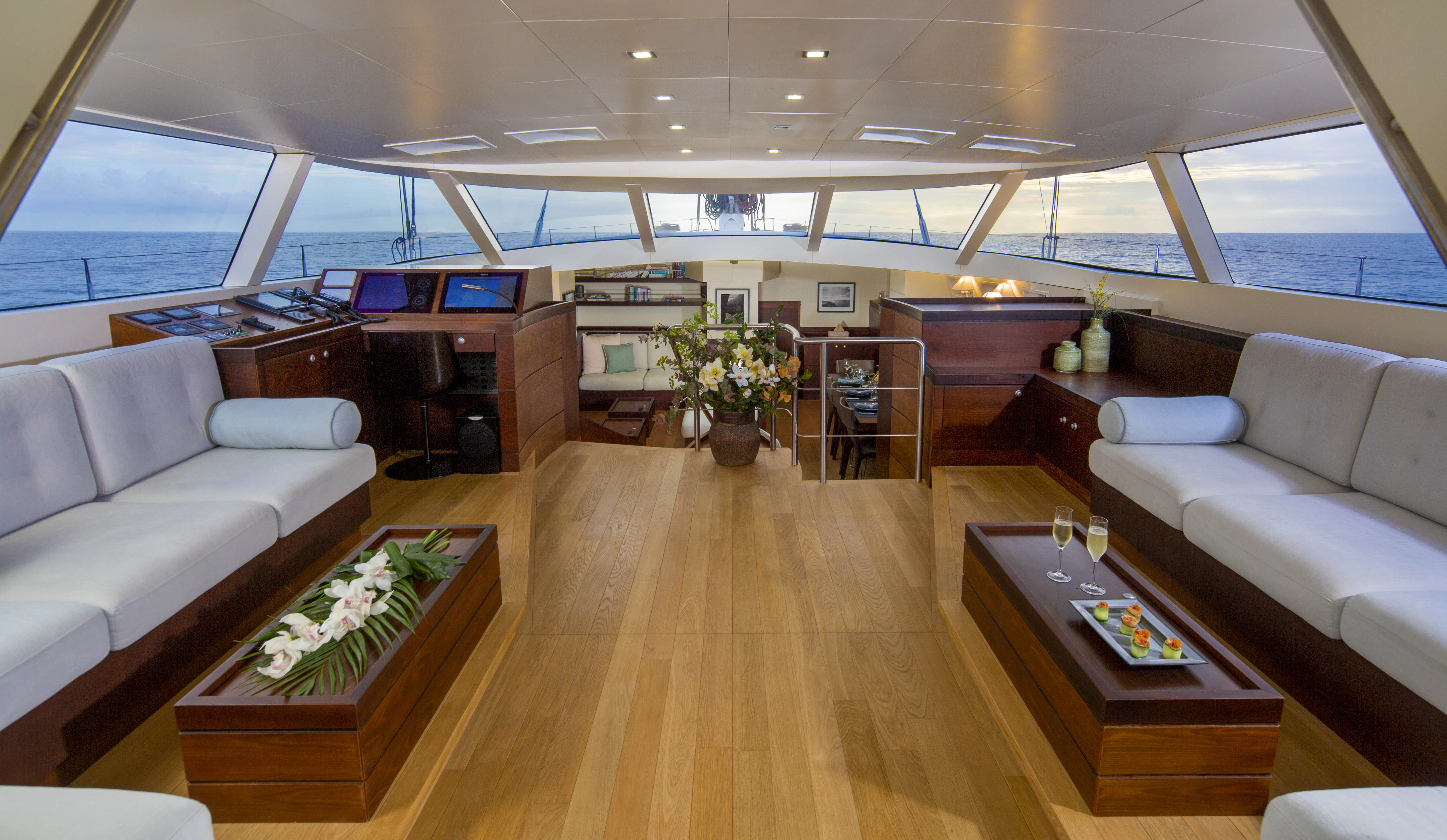 a room with a wood floor and white couches aboard RADIANCE Yacht for Charter