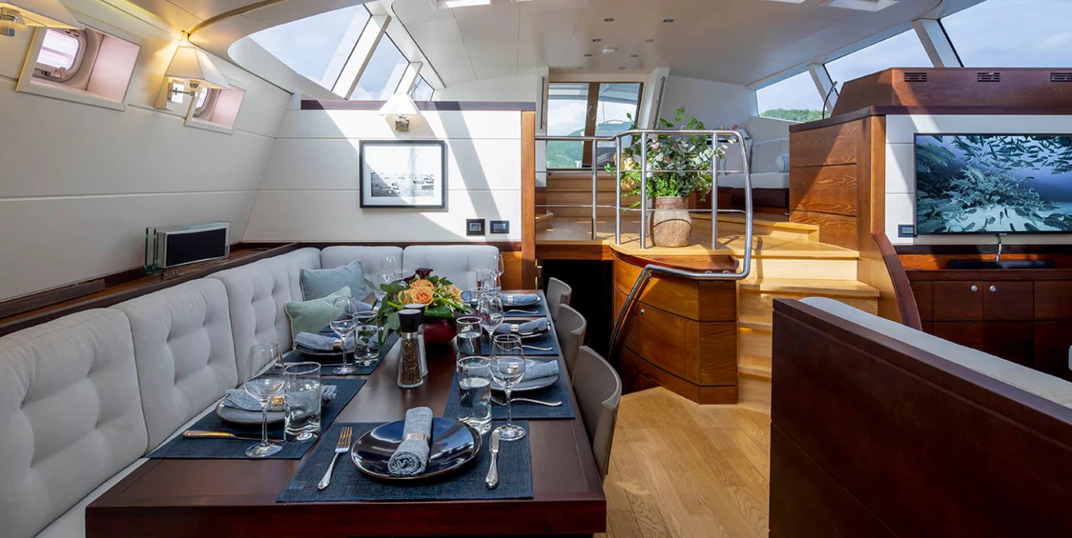 a large dining table with glasses and plates on it aboard RADIANCE Yacht for Charter