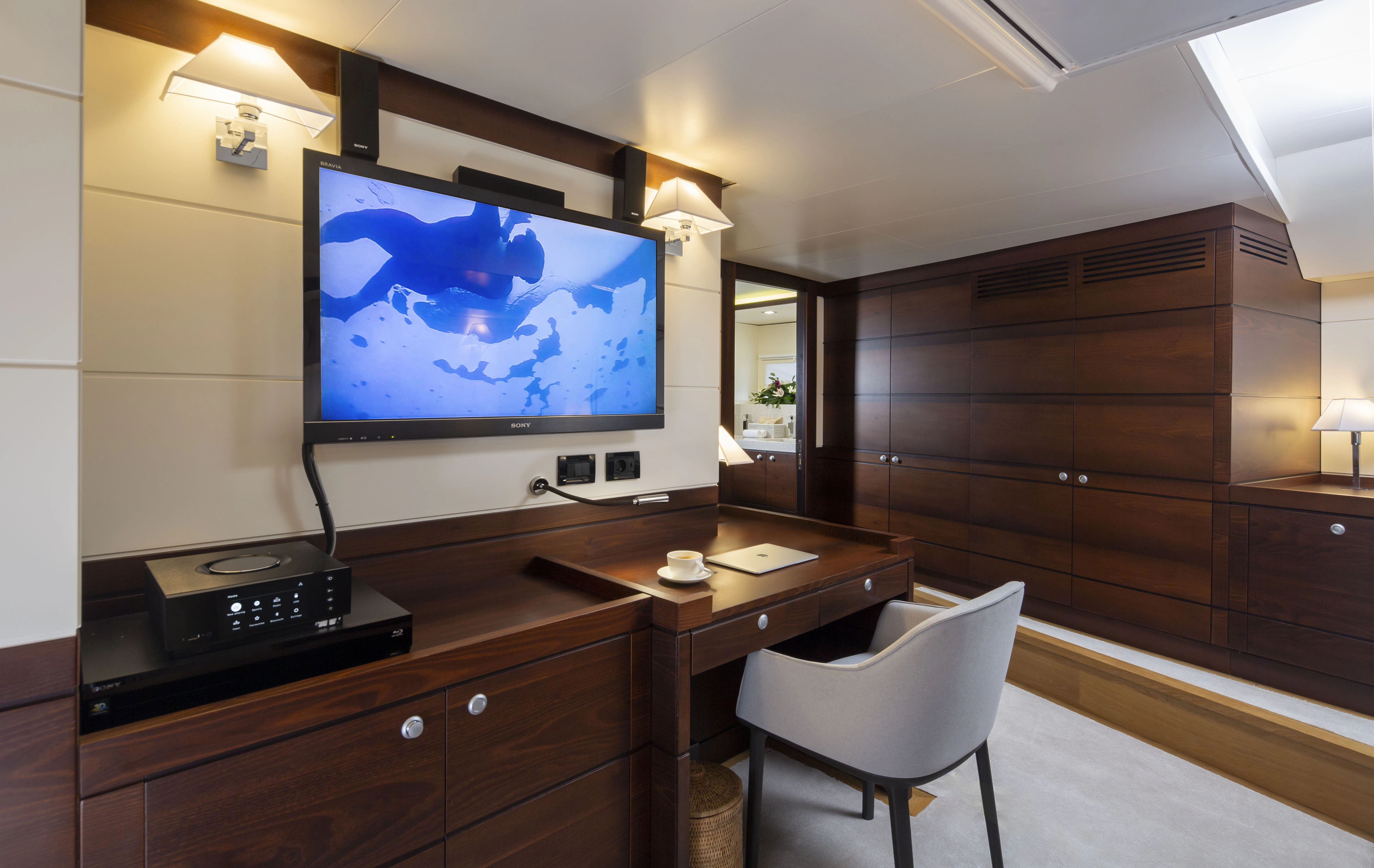 a room with a tv and a chair aboard RADIANCE Yacht for Charter
