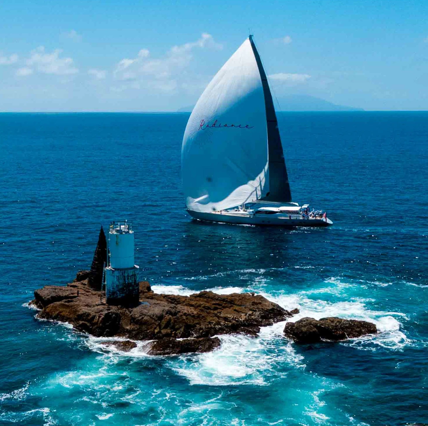 a sailboat on a small island aboard RADIANCE Yacht for Charter