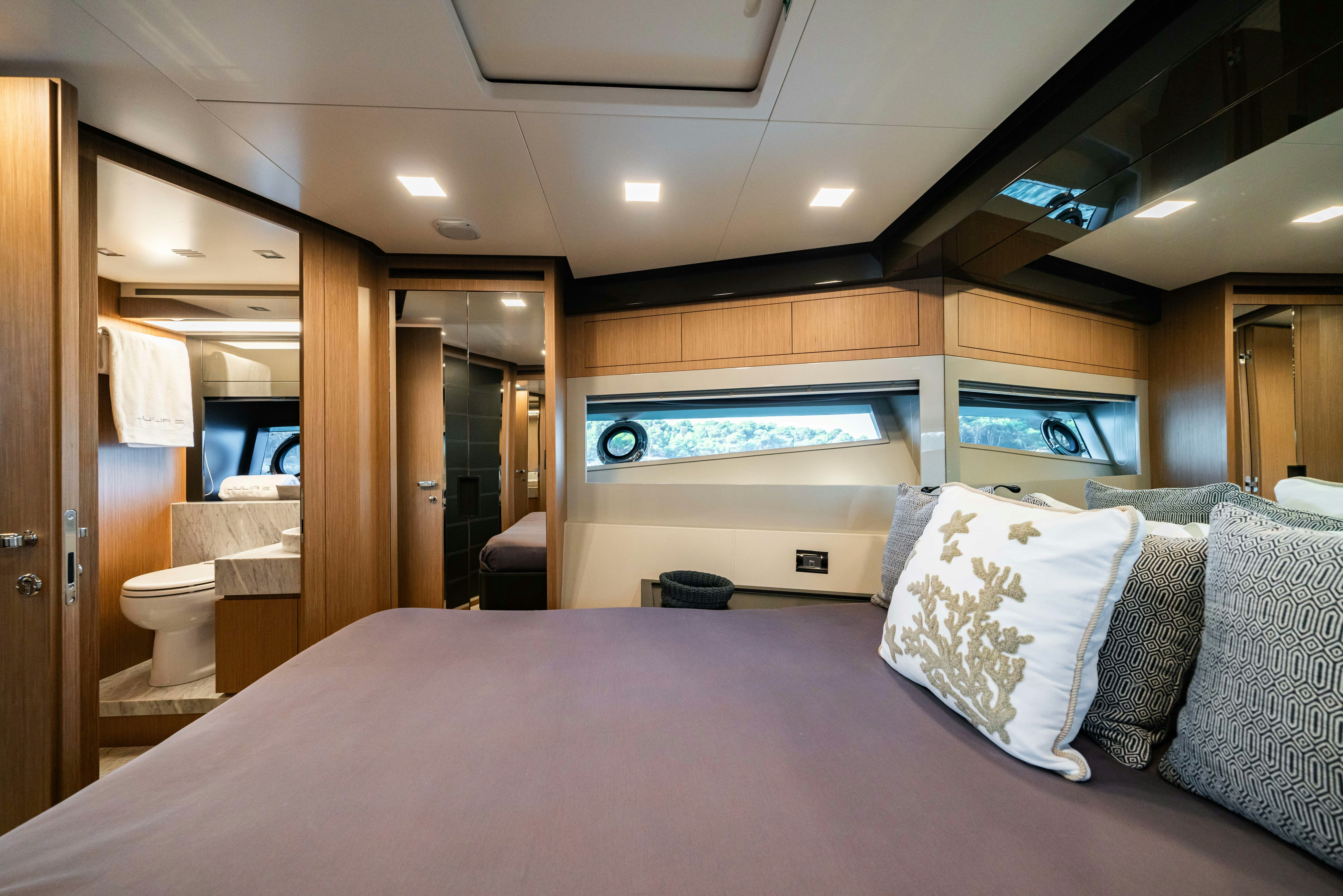 a bed with a purple sheet aboard XANADU 76 Yacht for Sale