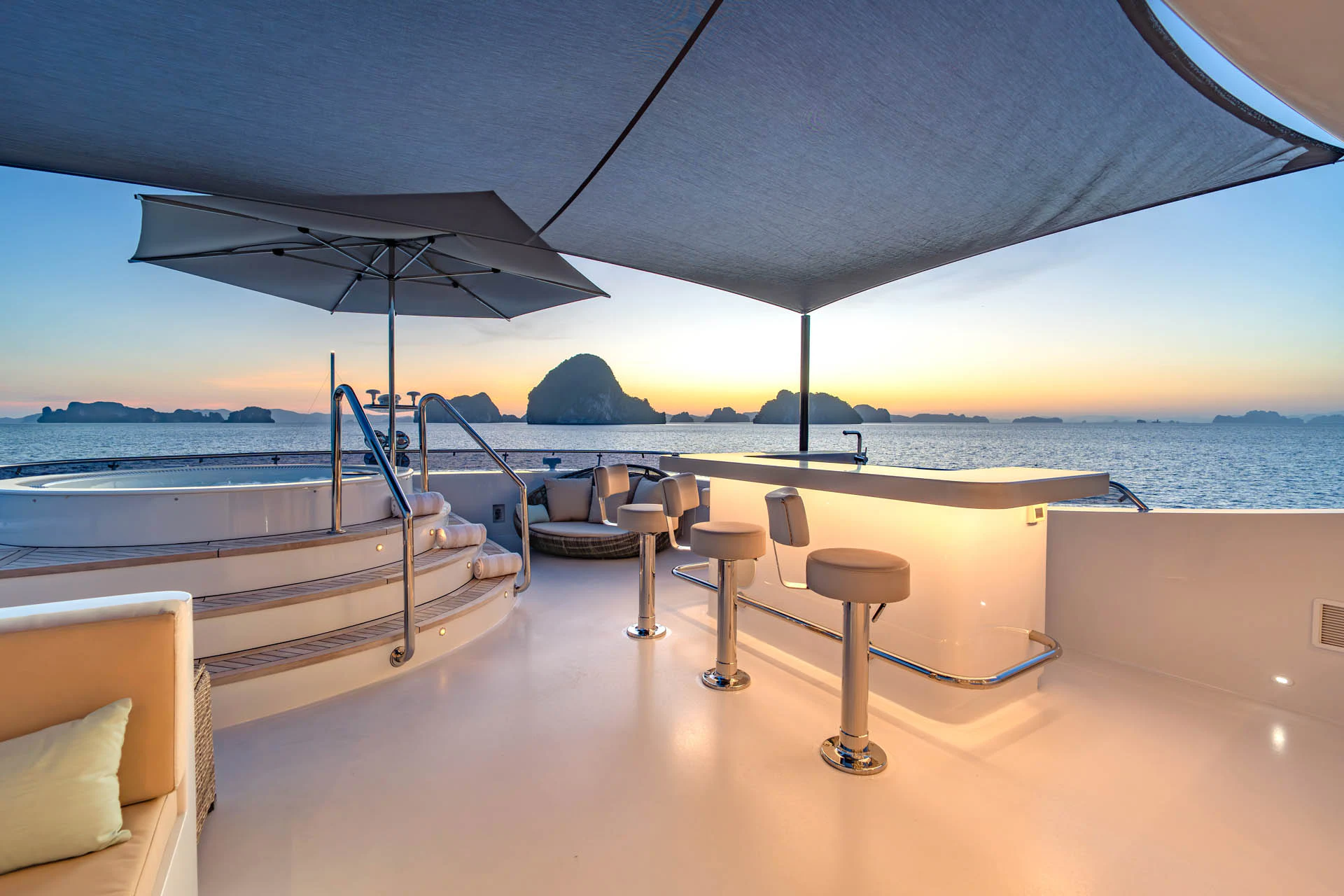 a lounge area with chairs and an umbrella aboard SWEET CAROLINE II Yacht for Sale