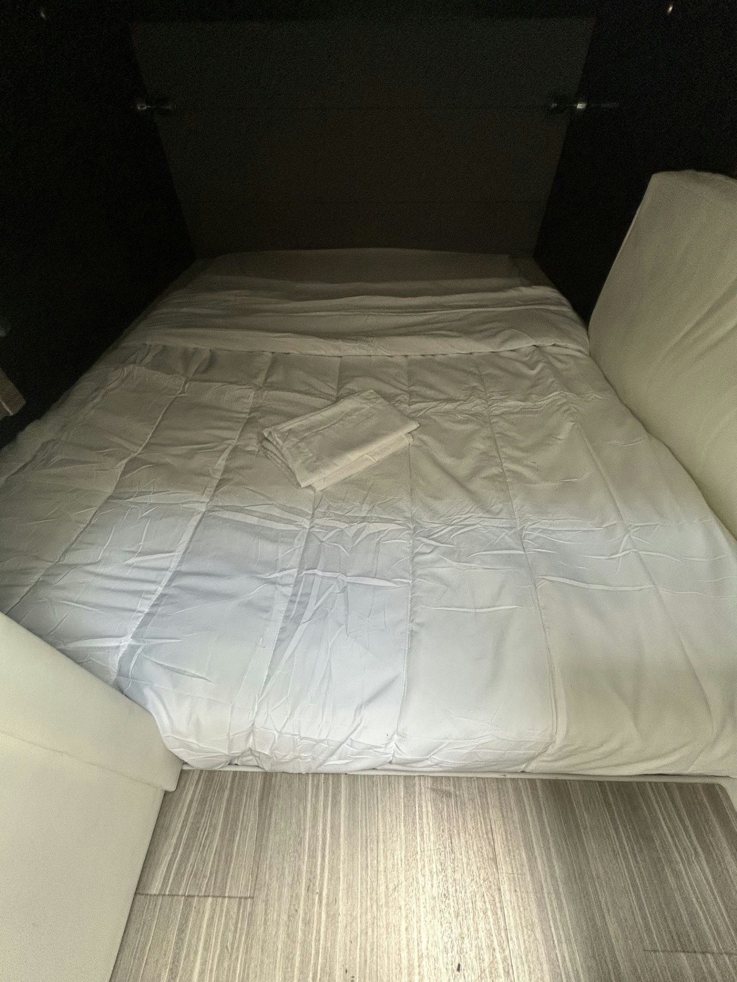 a bed with a white sheet aboard TRUE Yacht for Sale