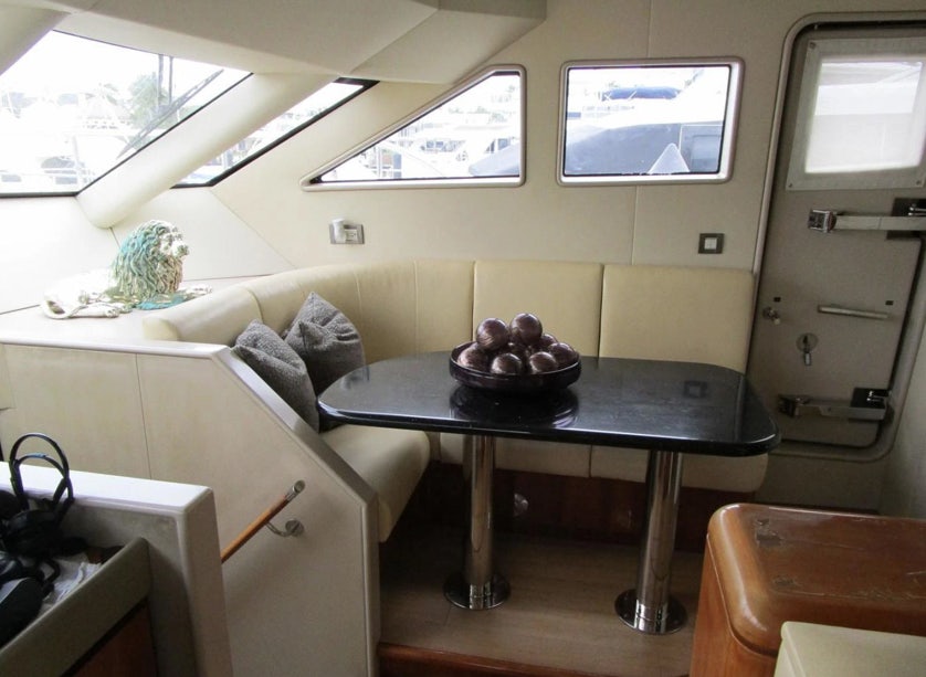 a room with a table and couches aboard FANCIER NANCI Yacht for Sale