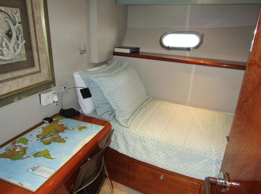 a bed with a table and a mirror above it aboard FANCIER NANCI Yacht for Sale
