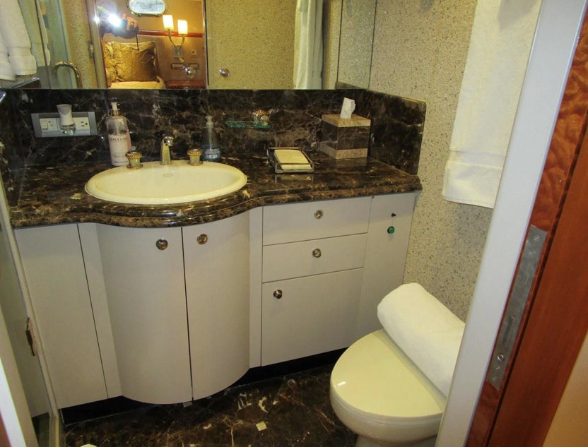 a bathroom with a countertop sink and toilet aboard FANCIER NANCI Yacht for Sale