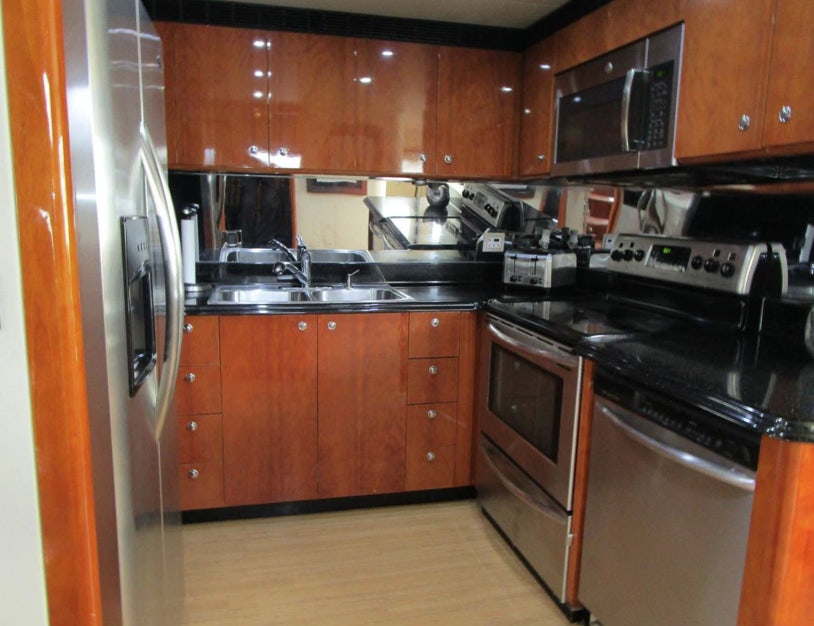 a kitchen with wooden cabinets aboard FANCIER NANCI Yacht for Sale