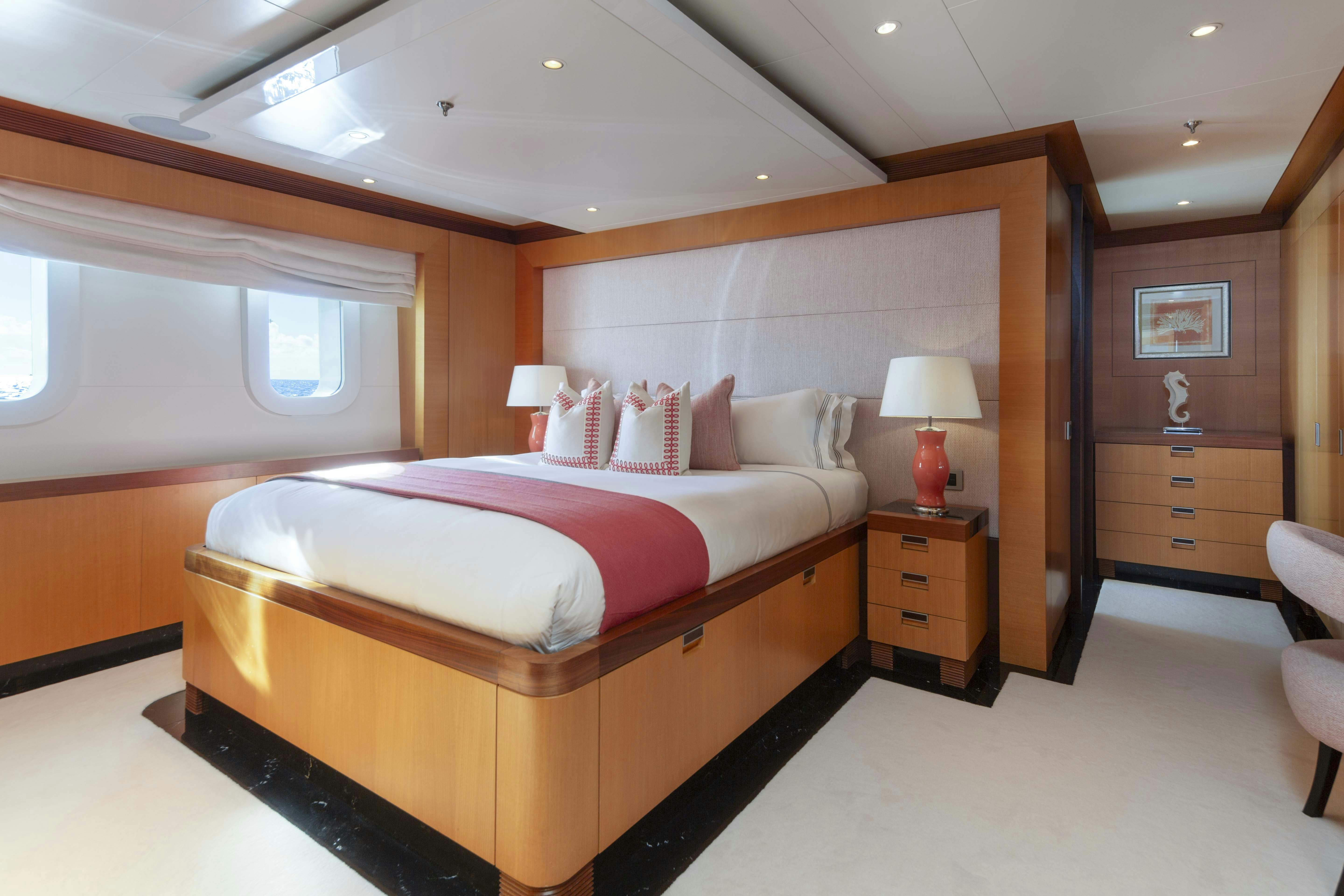 a bedroom with a bed and a window aboard LA BLANCA Yacht for Charter