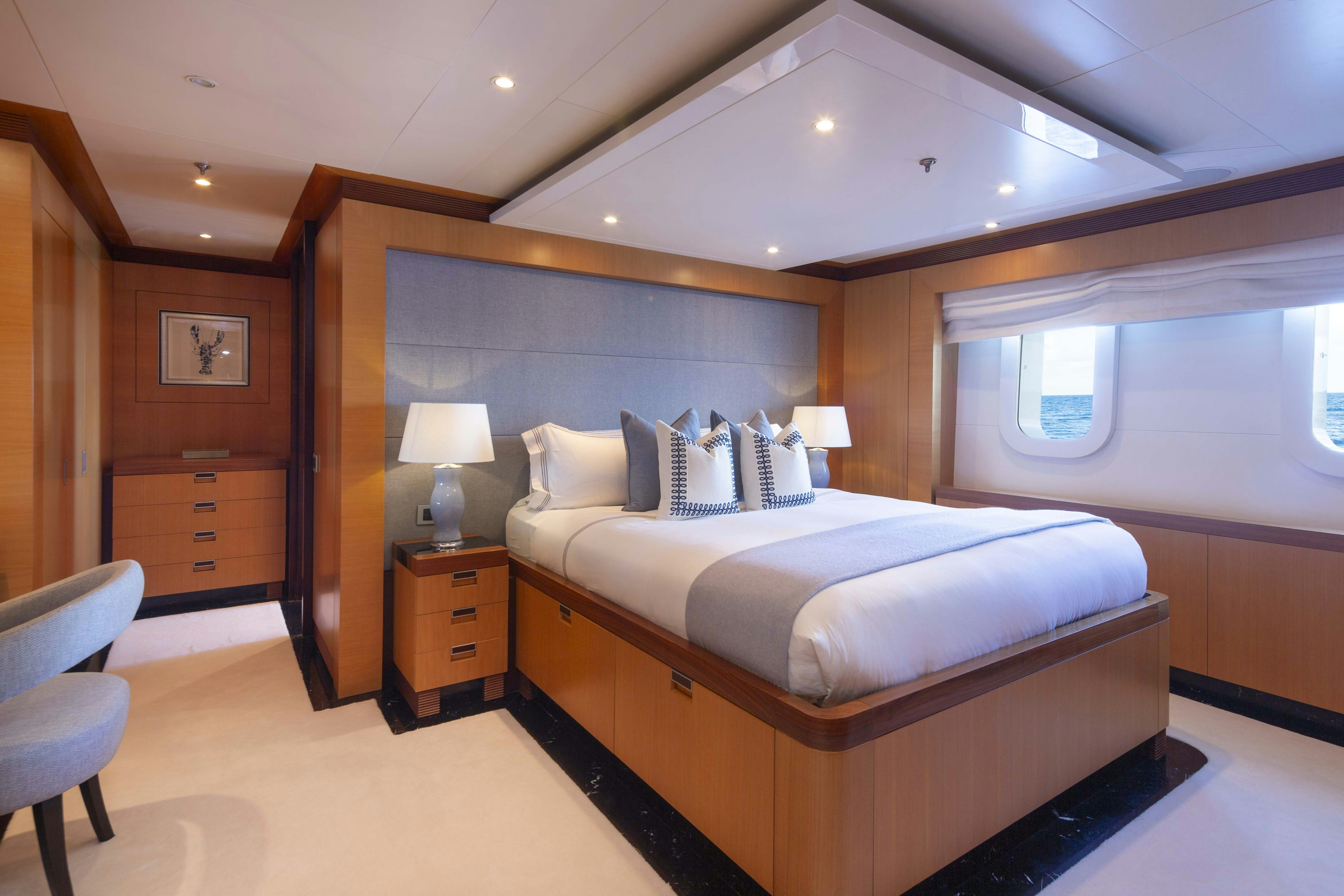 a bedroom with a bed and a desk aboard LA BLANCA Yacht for Charter