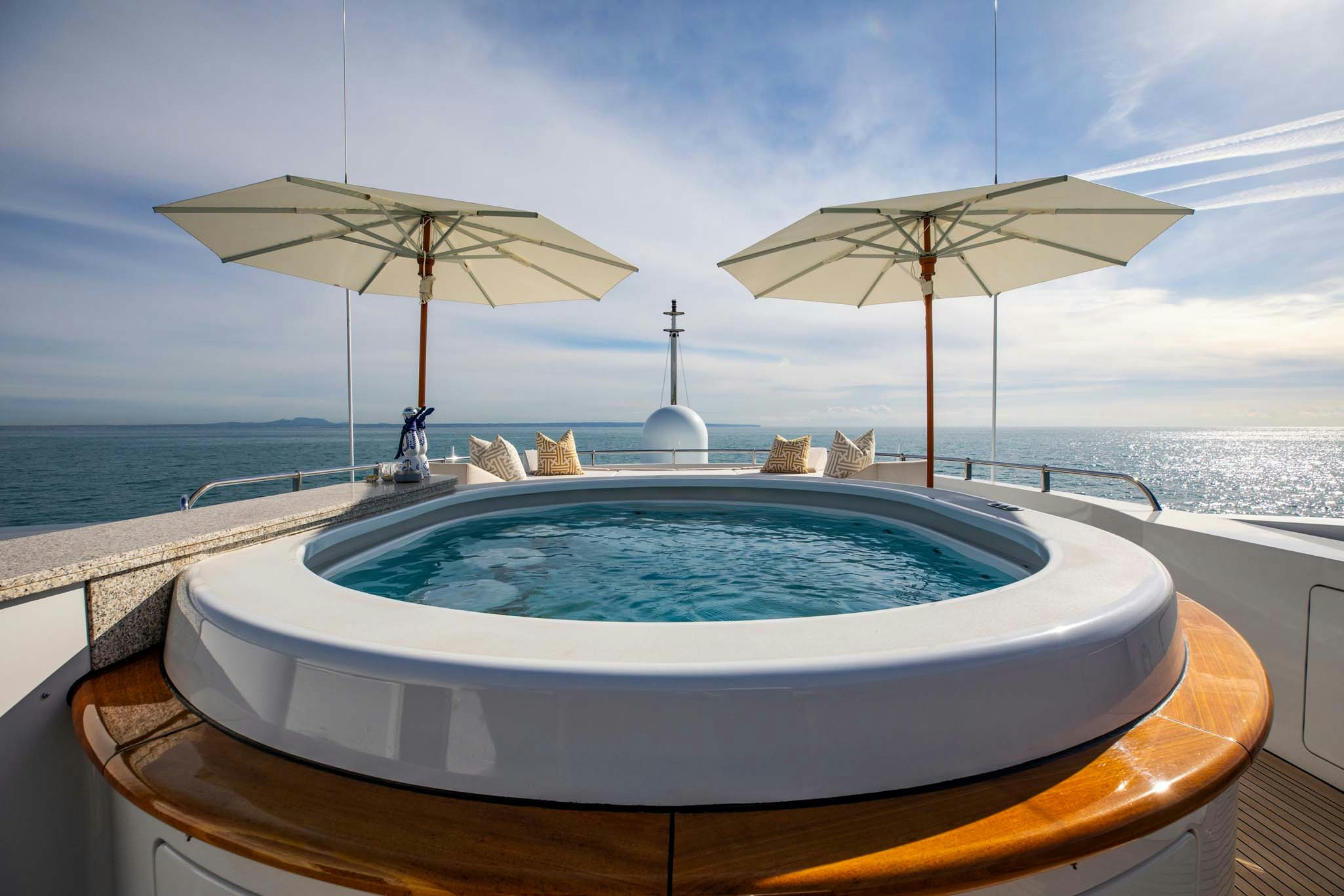 a pool with umbrellas and chairs on a beach aboard LA BLANCA Yacht for Charter