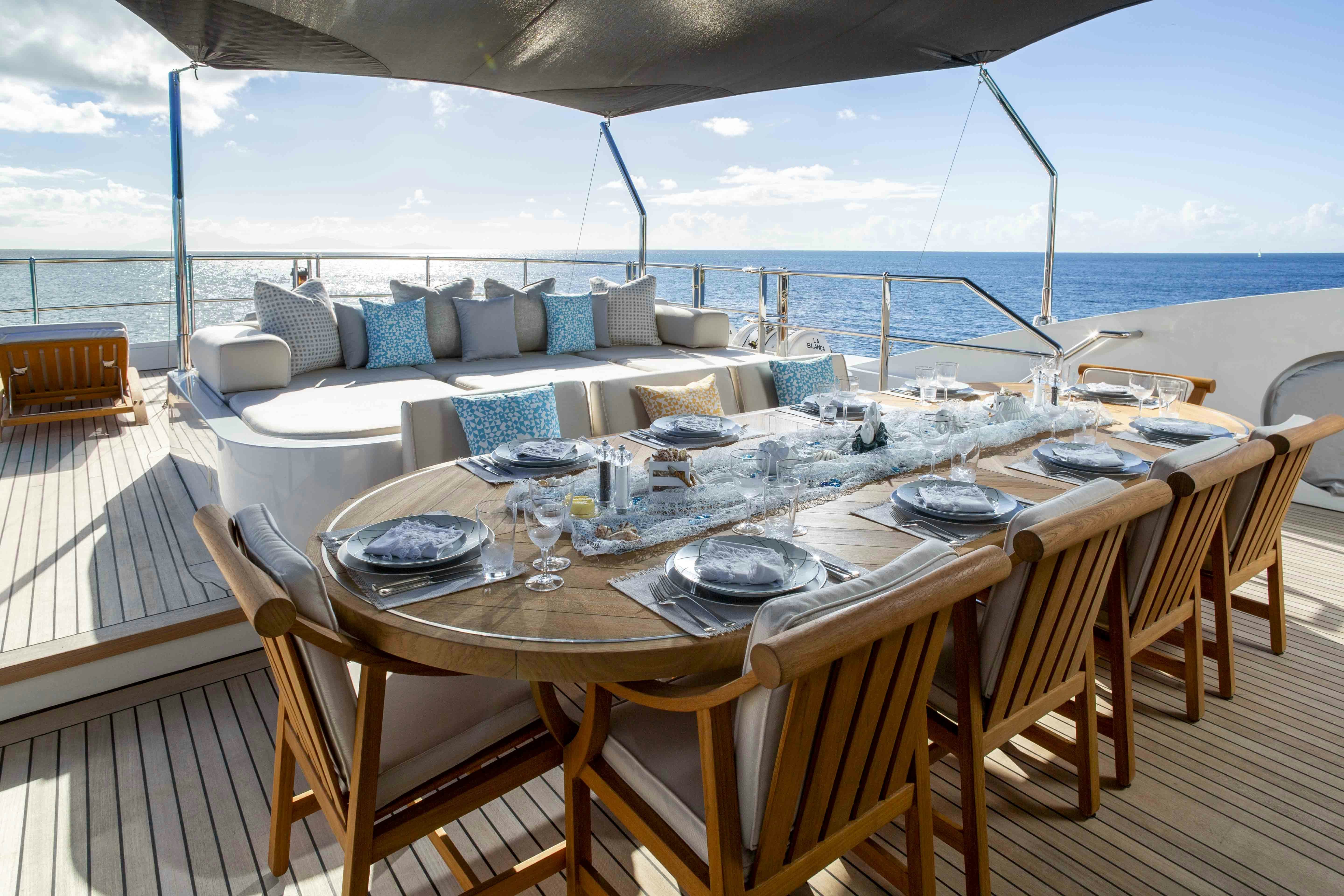 a table set for a meal on a deck overlooking the ocean aboard LA BLANCA Yacht for Charter