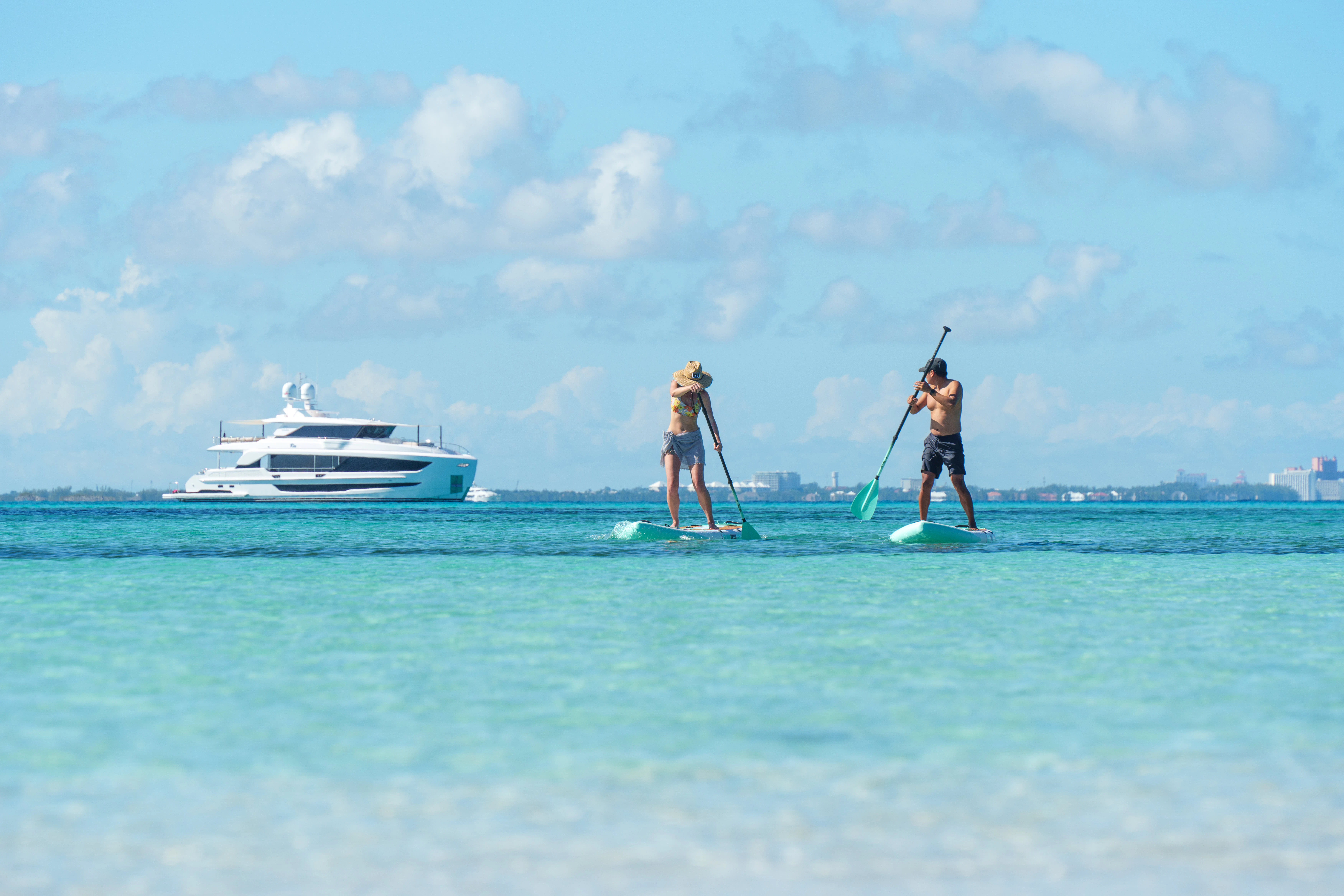 a group of people on surfboards in the ocean with a boat in the background aboard RIO Yacht for Charter