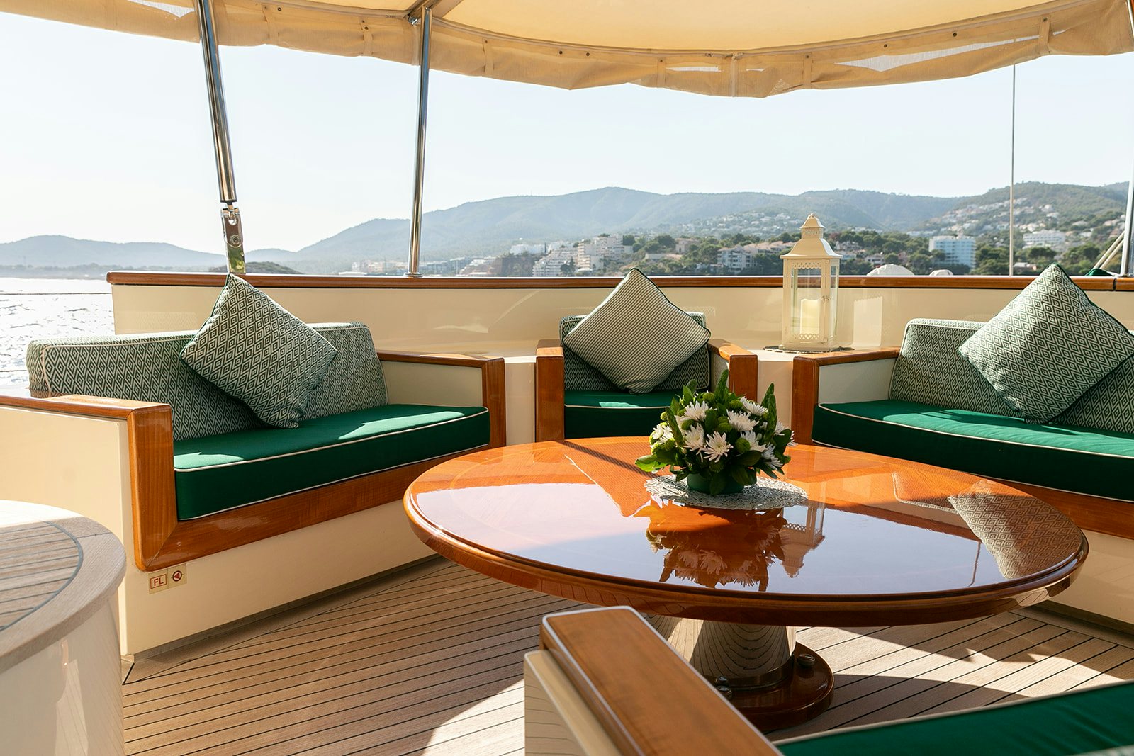 a table with pillows and a vase of flowers on it aboard NORFOLK STAR Yacht for Sale