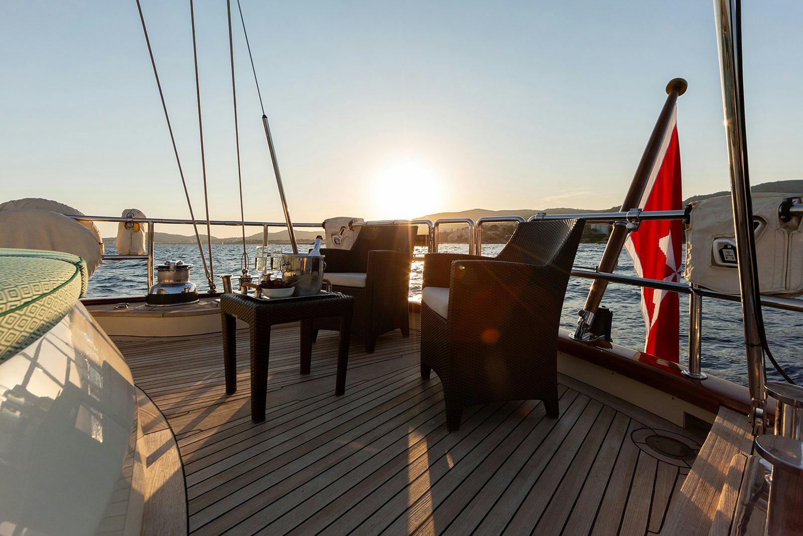 a deck with a chair and a table on it aboard NORFOLK STAR Yacht for Sale