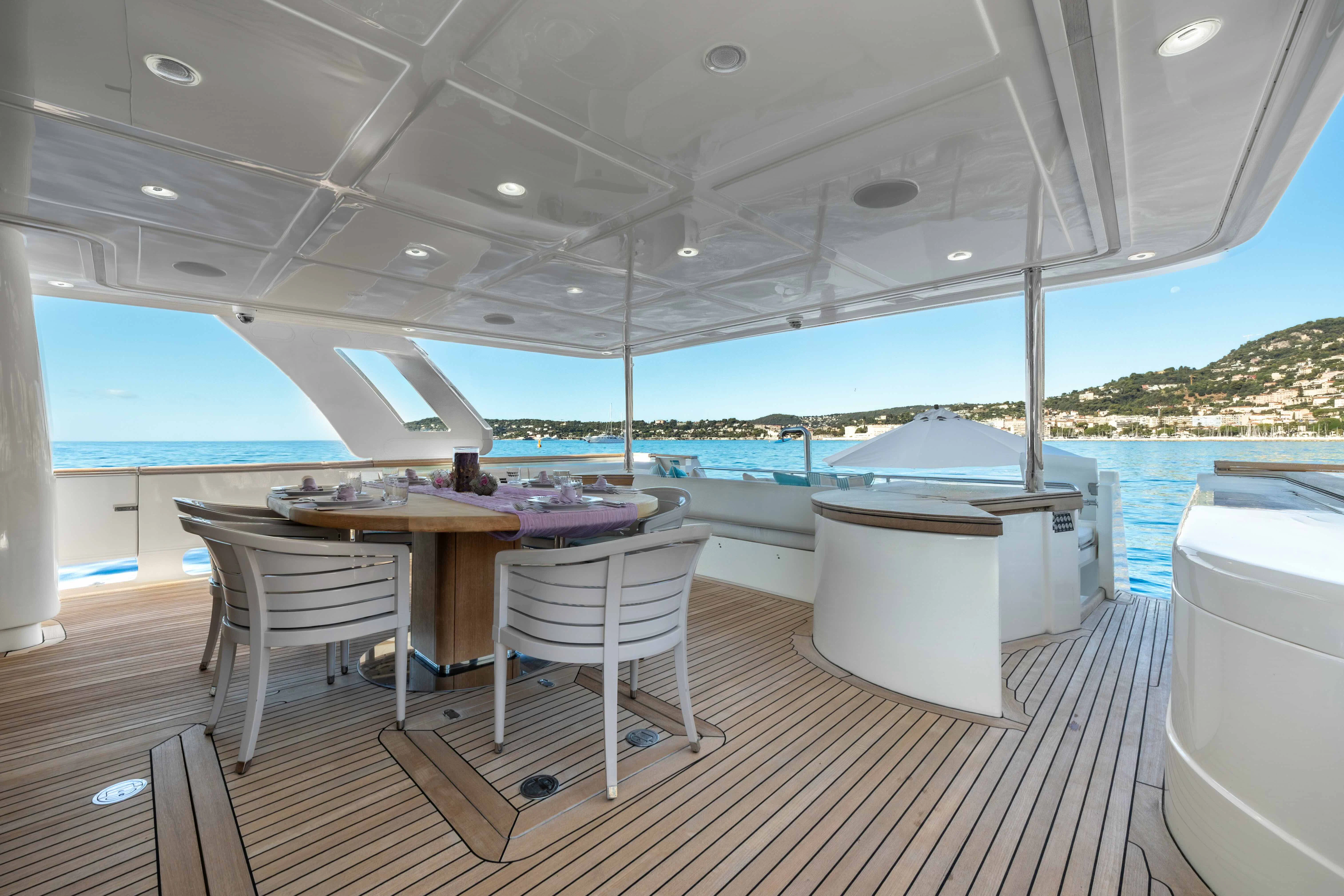 a table and chairs on a deck aboard CENTURION Yacht for Sale
