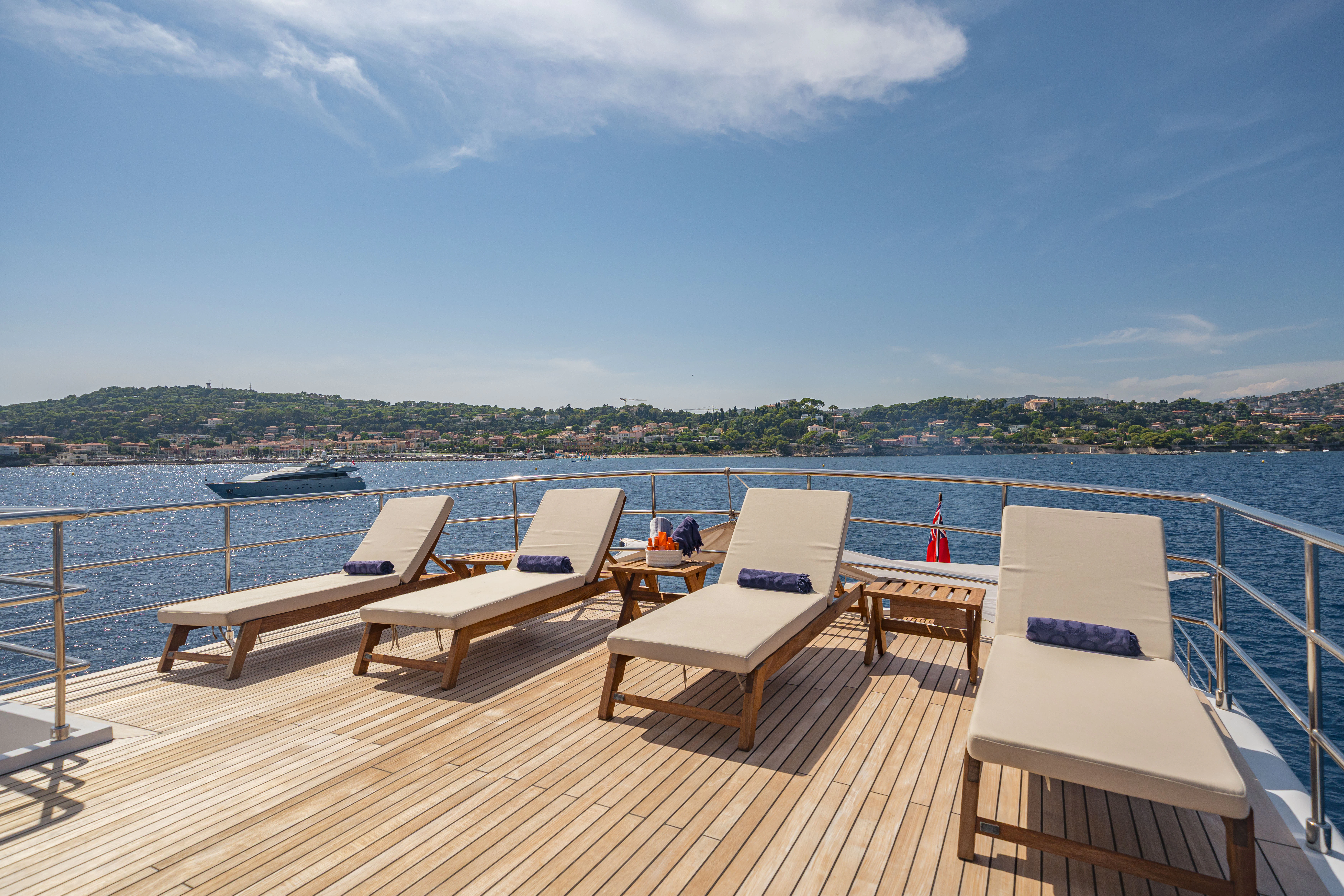 a deck with lounge chairs on it aboard KORU Yacht for Sale