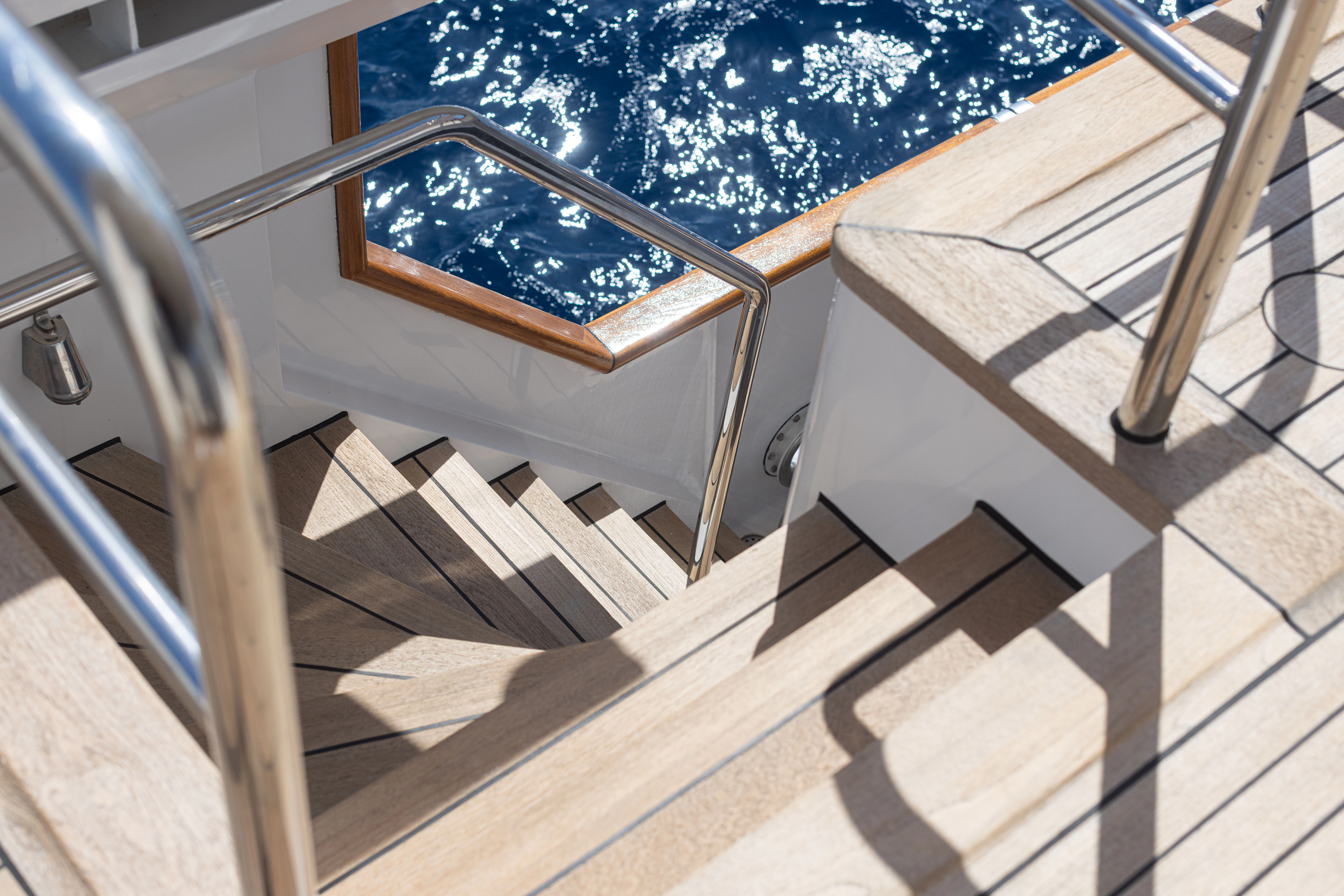 a wooden chair on a deck aboard KORU Yacht for Sale