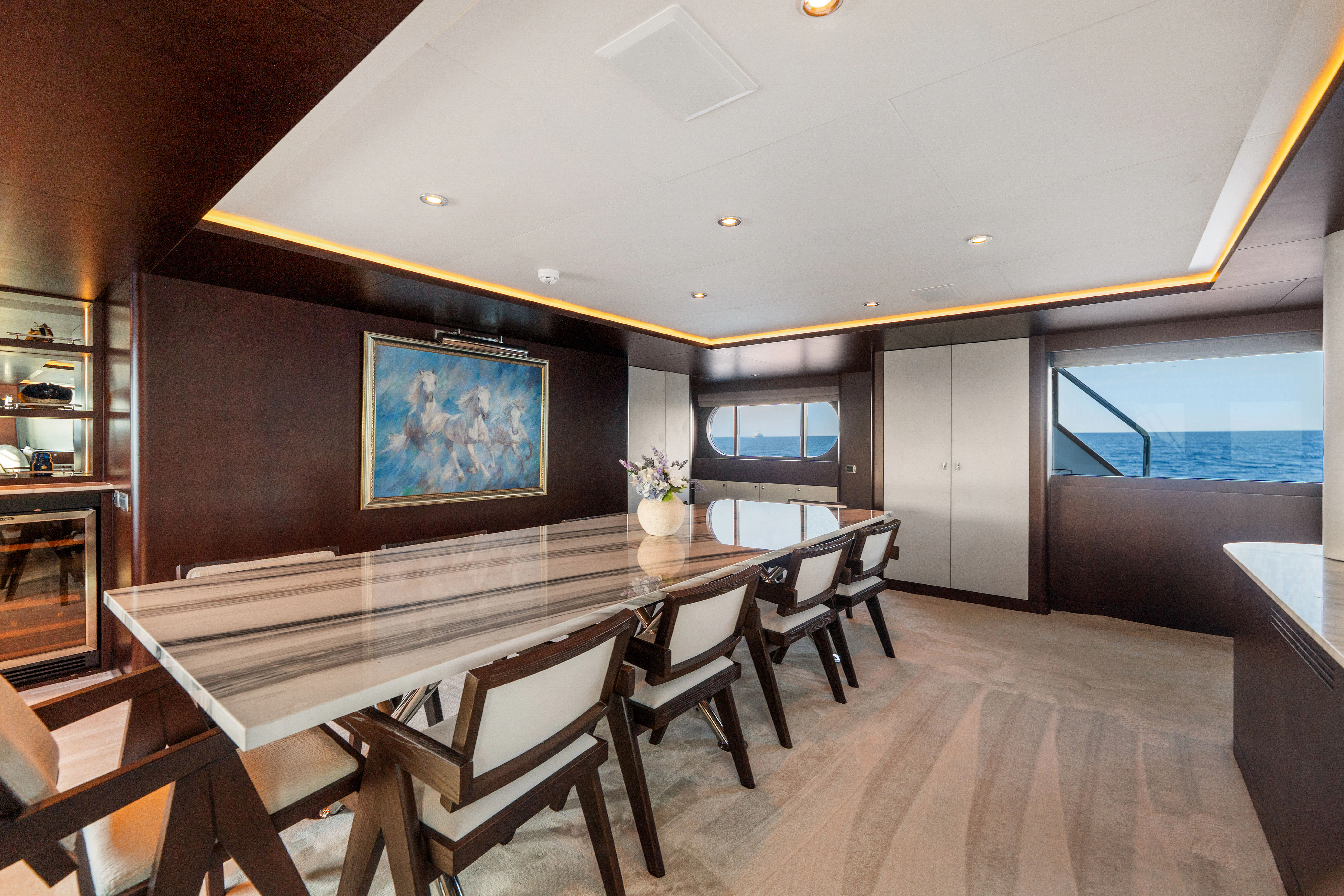 a room with a table and chairs aboard KORU Yacht for Sale