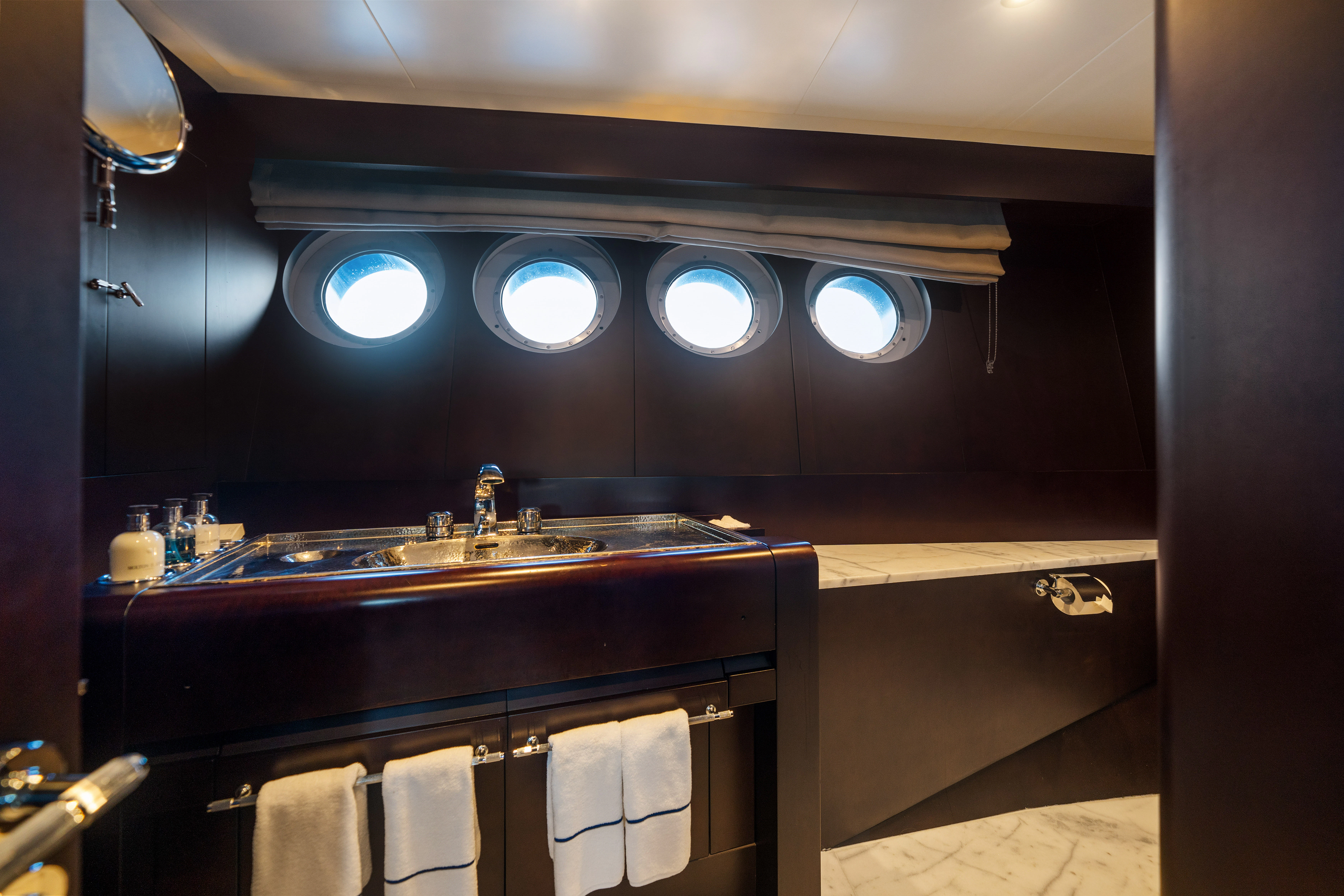 a bathroom with a countertop sink and a mirror aboard KORU Yacht for Sale