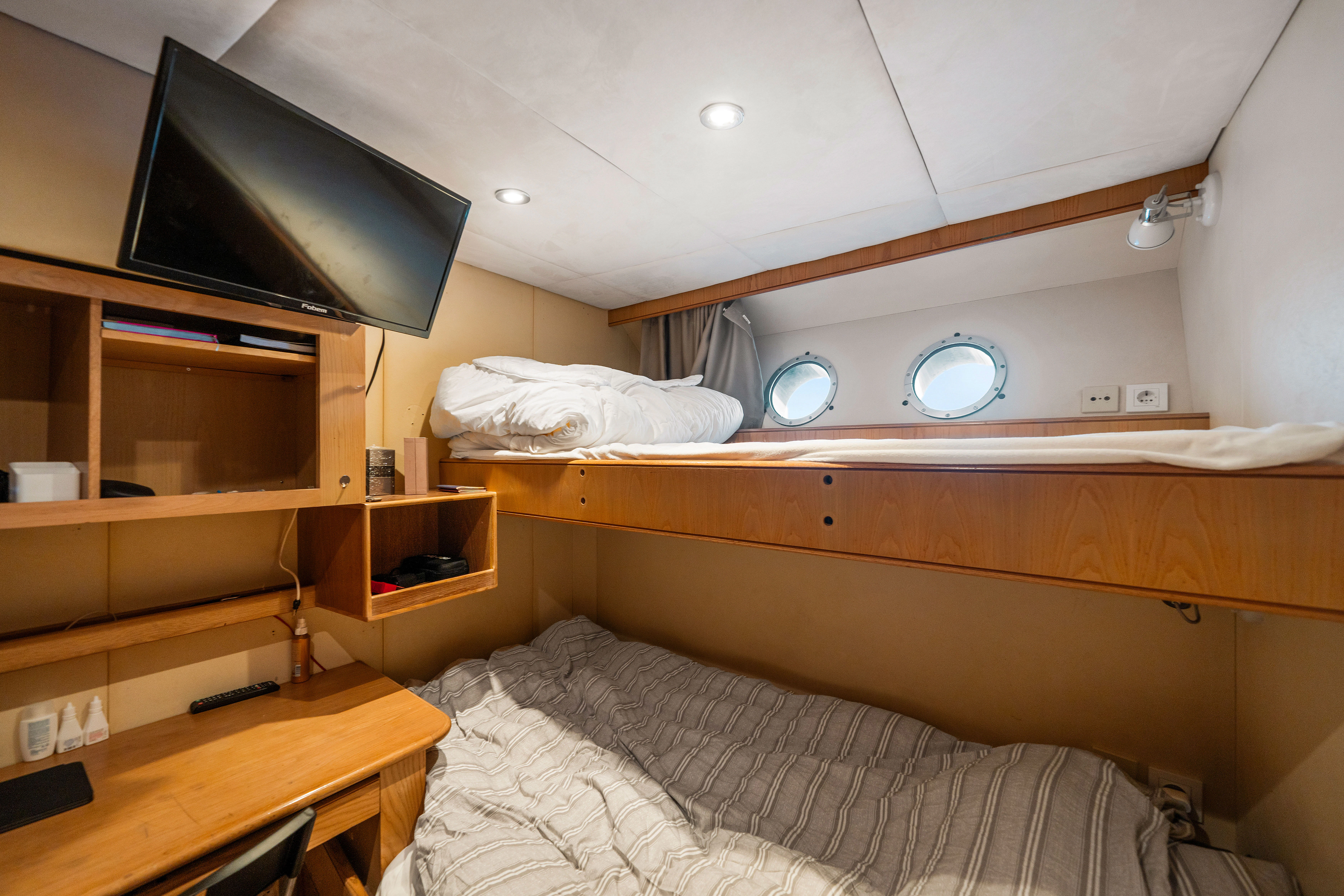 a bed with a television on the wall aboard KORU Yacht for Sale