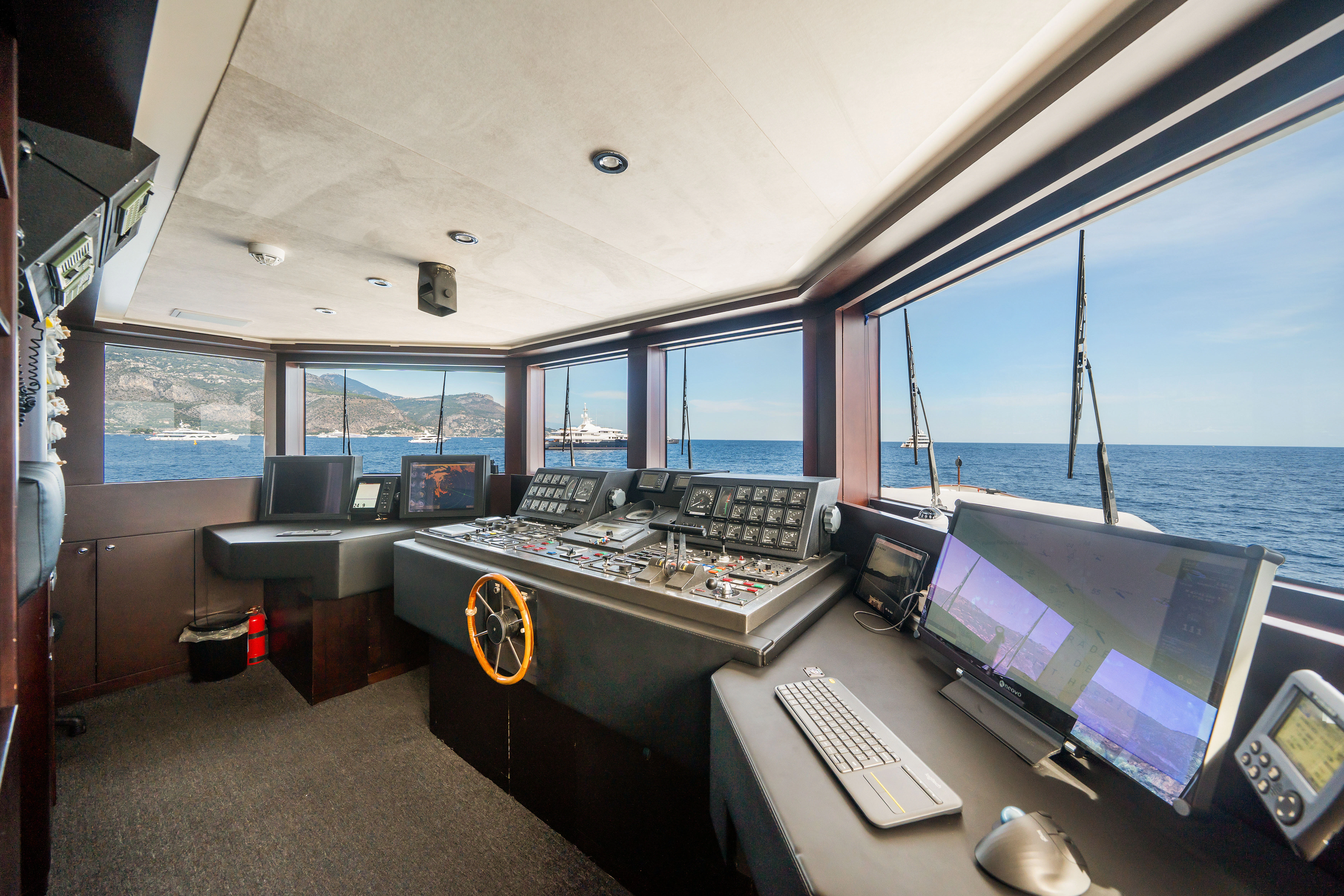 a room with a large window and a desk with computers on it aboard KORU Yacht for Sale
