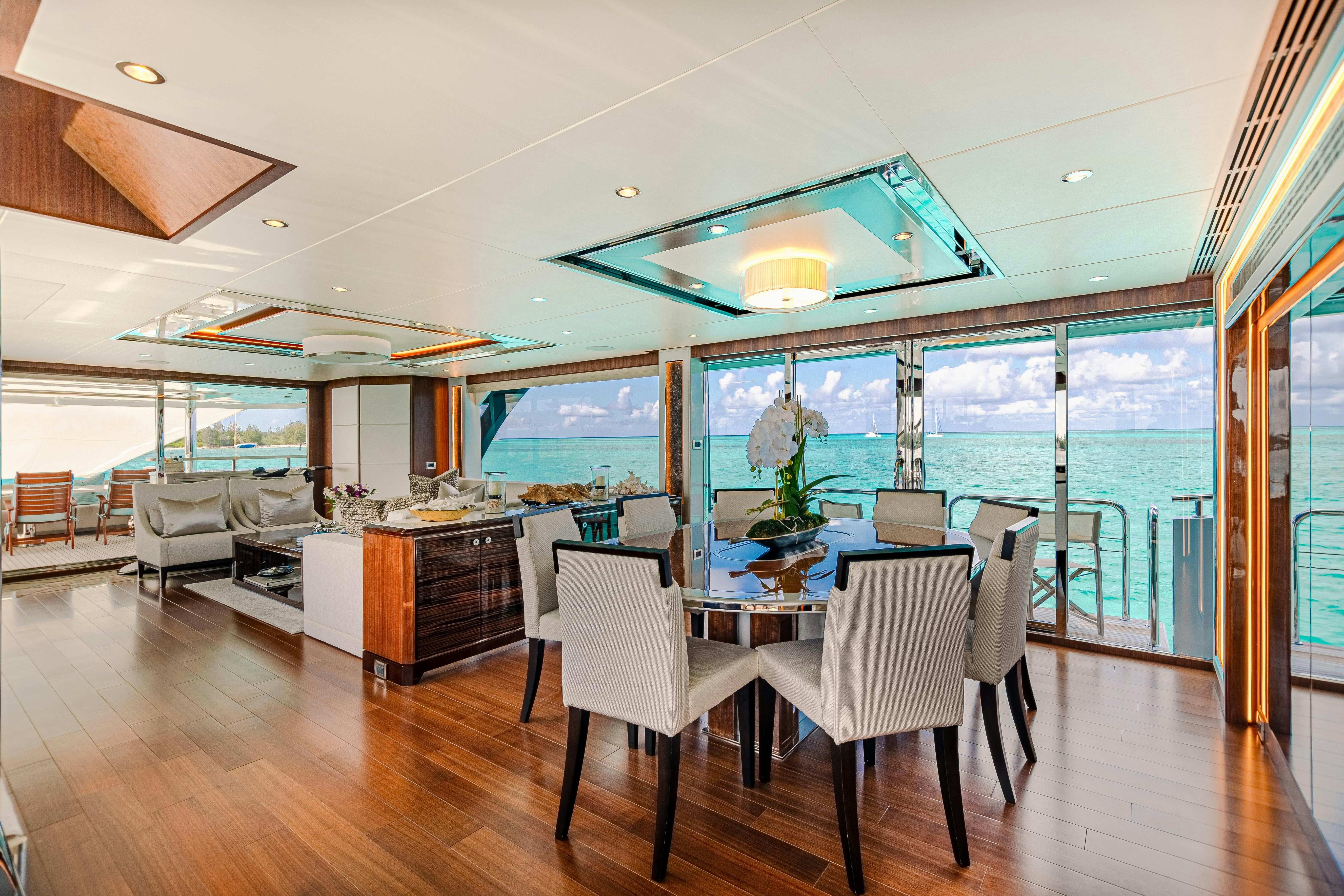 a large room with a table and chairs and a large window aboard I C Yacht for Charter