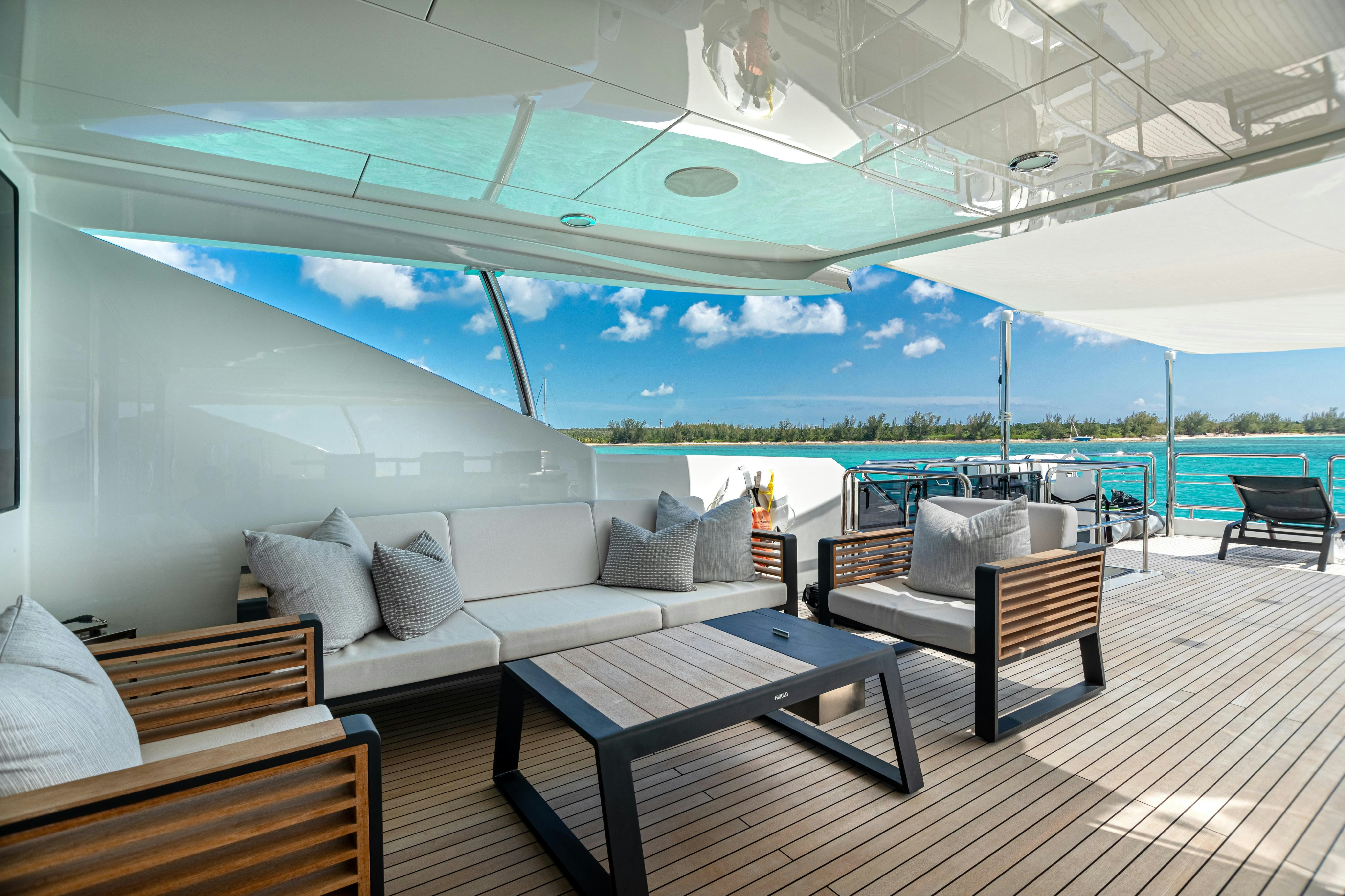a lounge area with a table and chairs on a deck aboard I C Yacht for Charter