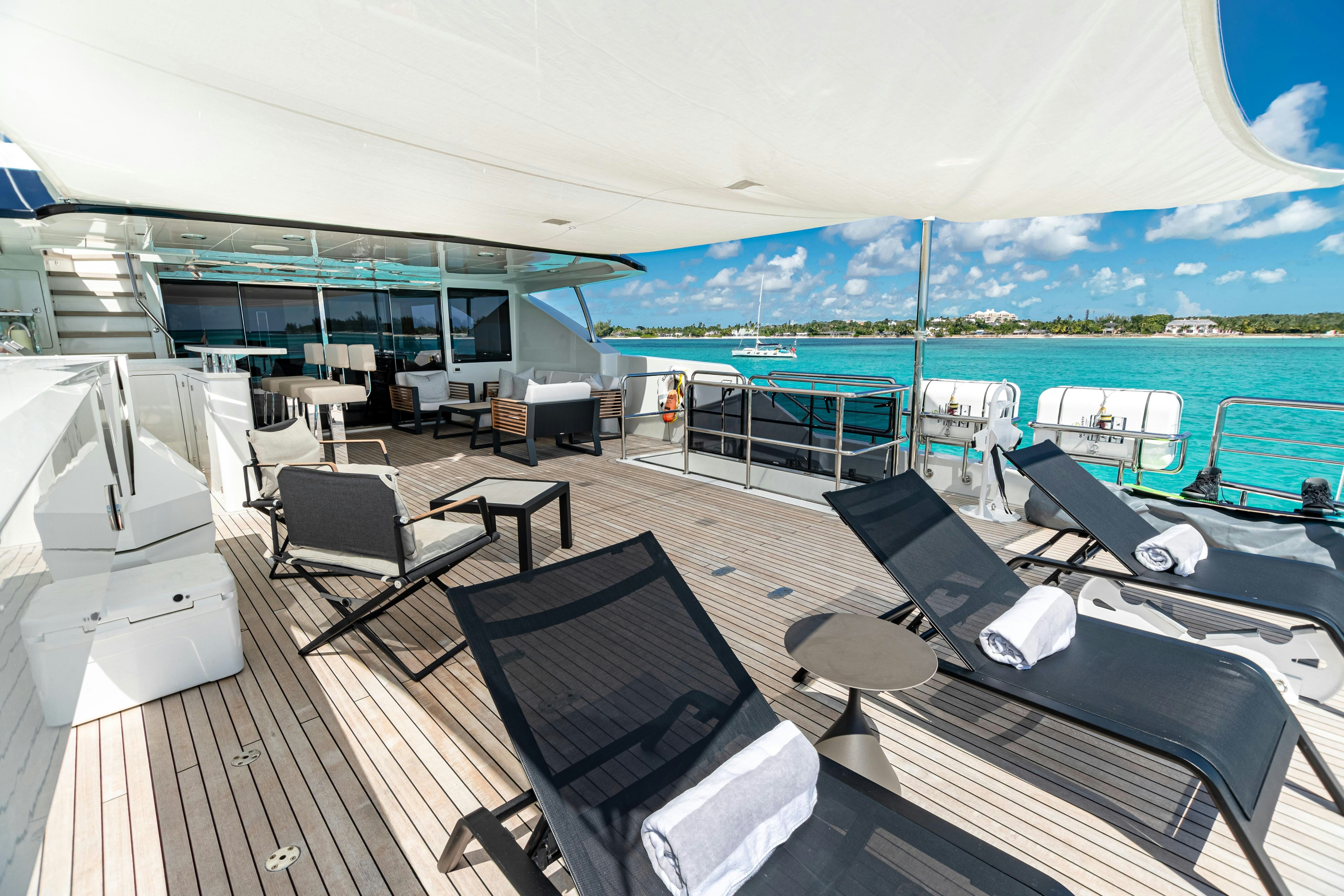 a room with a deck and chairs and a pool aboard I C Yacht for Charter