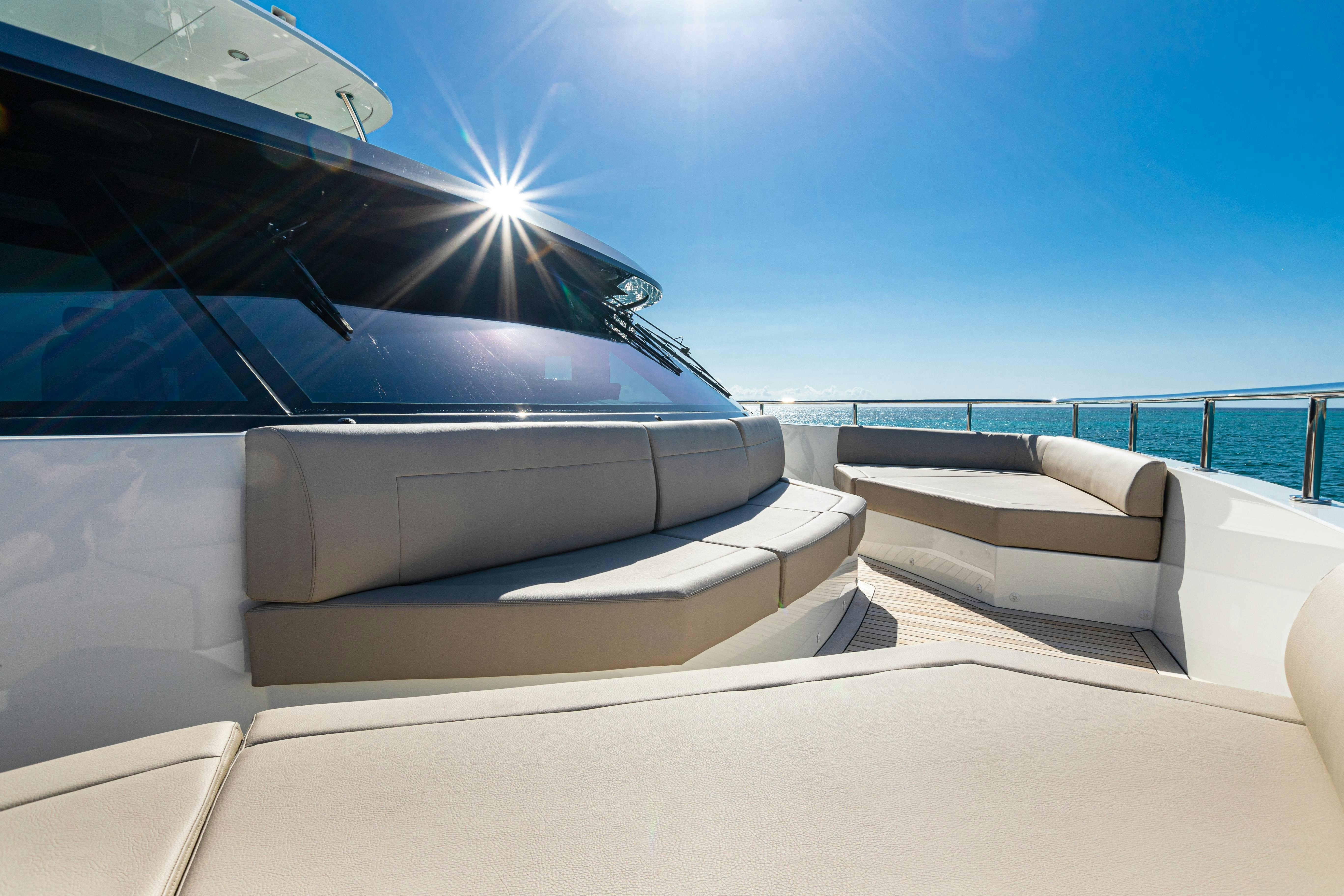 a white lounge chair next to a white sofa and a white sofa aboard I C Yacht for Charter