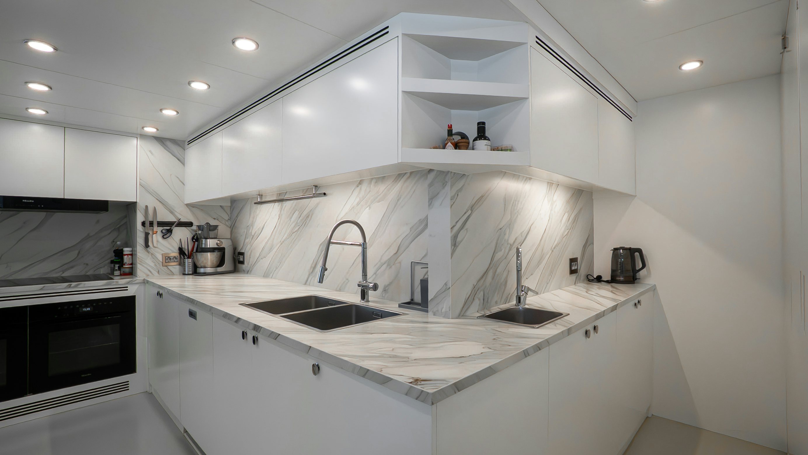 a kitchen with white cabinets aboard RAY Yacht for Sale