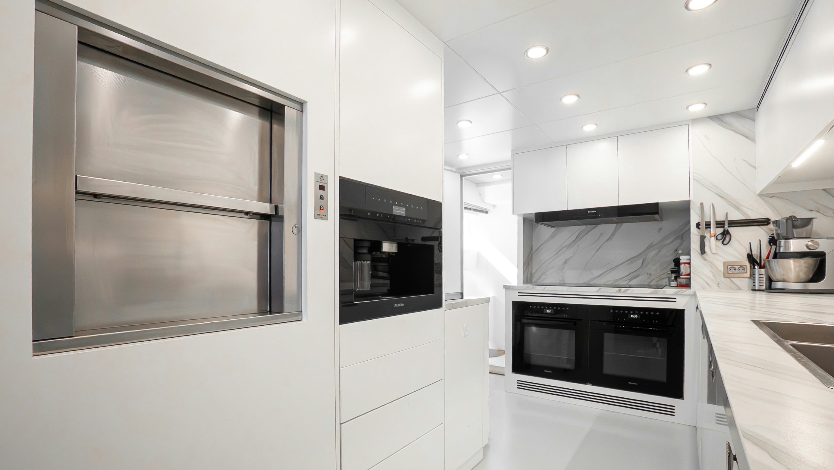 a kitchen with white cabinets aboard RAY Yacht for Sale