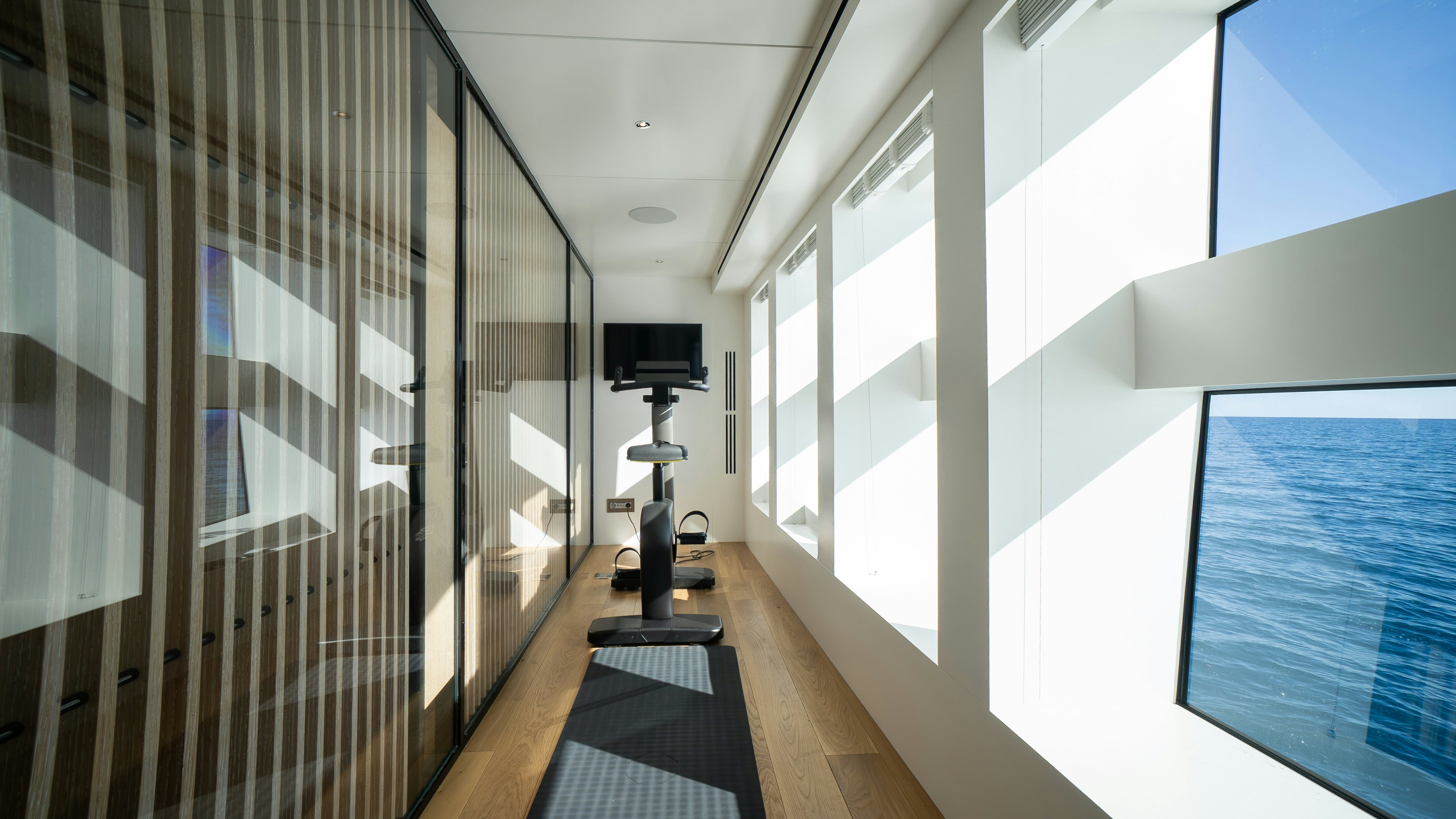 a room with a large window and a tv on the wall aboard RAY Yacht for Sale