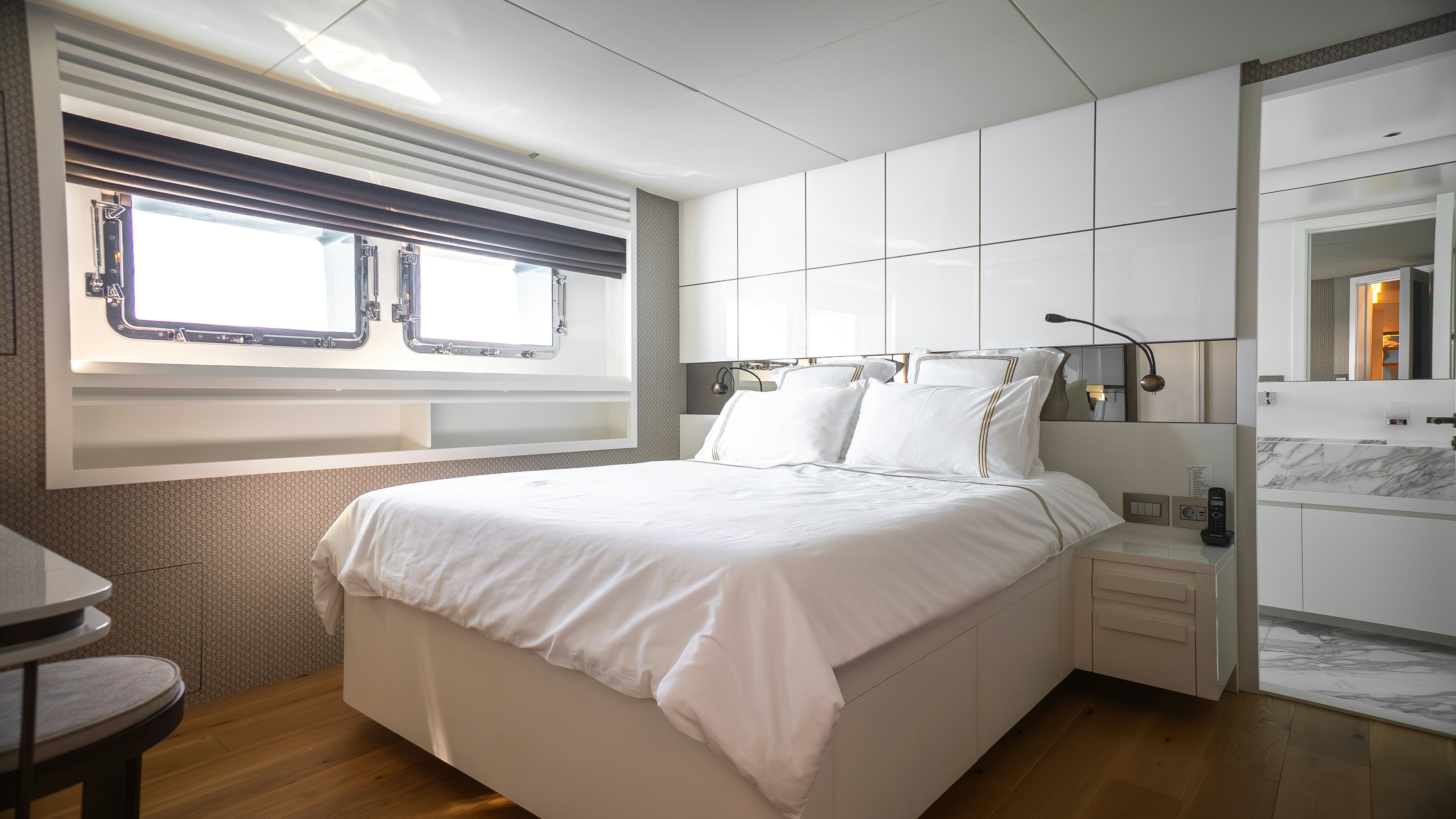 a room with a bed and a window aboard RAY Yacht for Sale