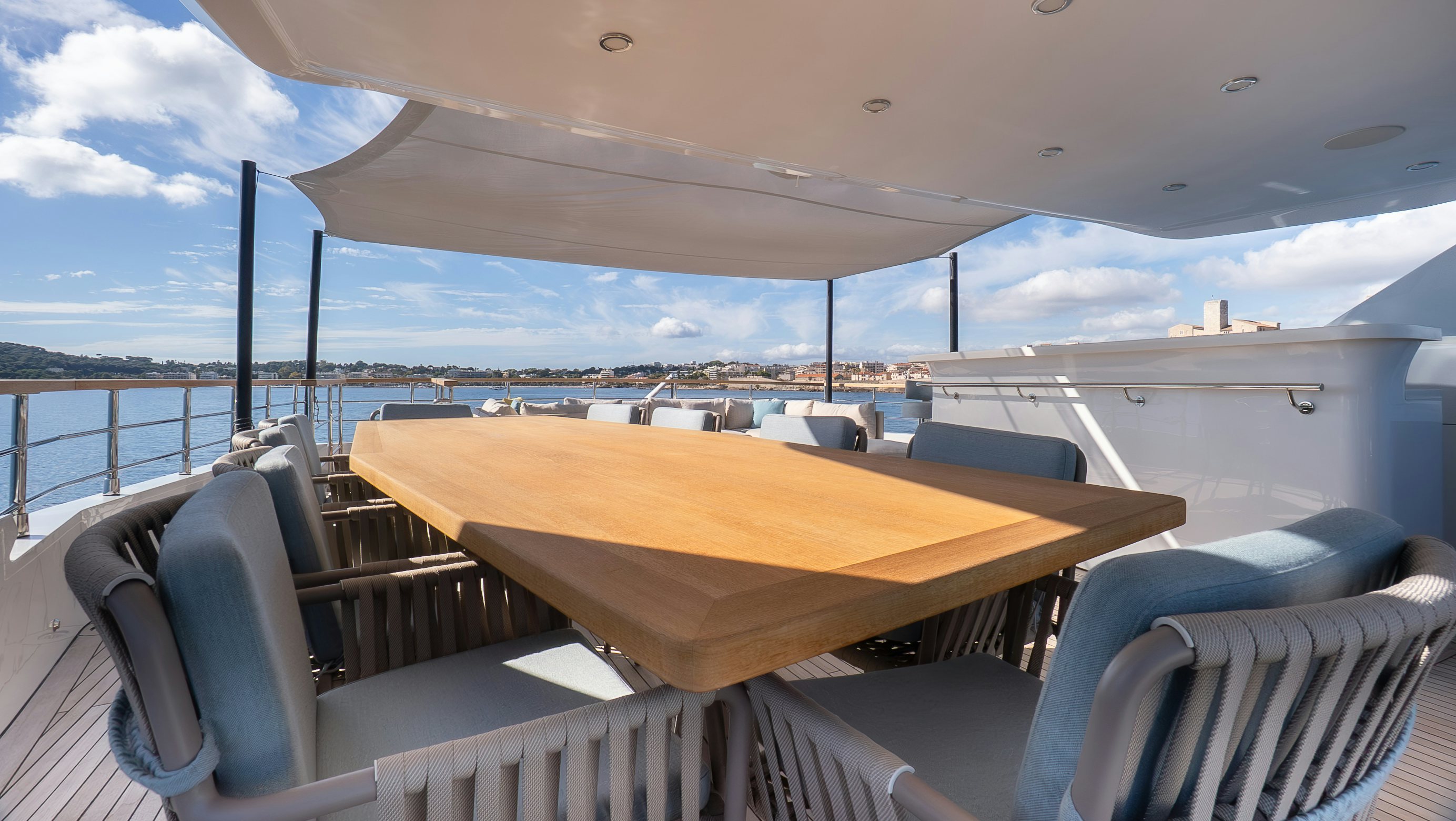 a deck with a table and chairs on it aboard RAY Yacht for Sale