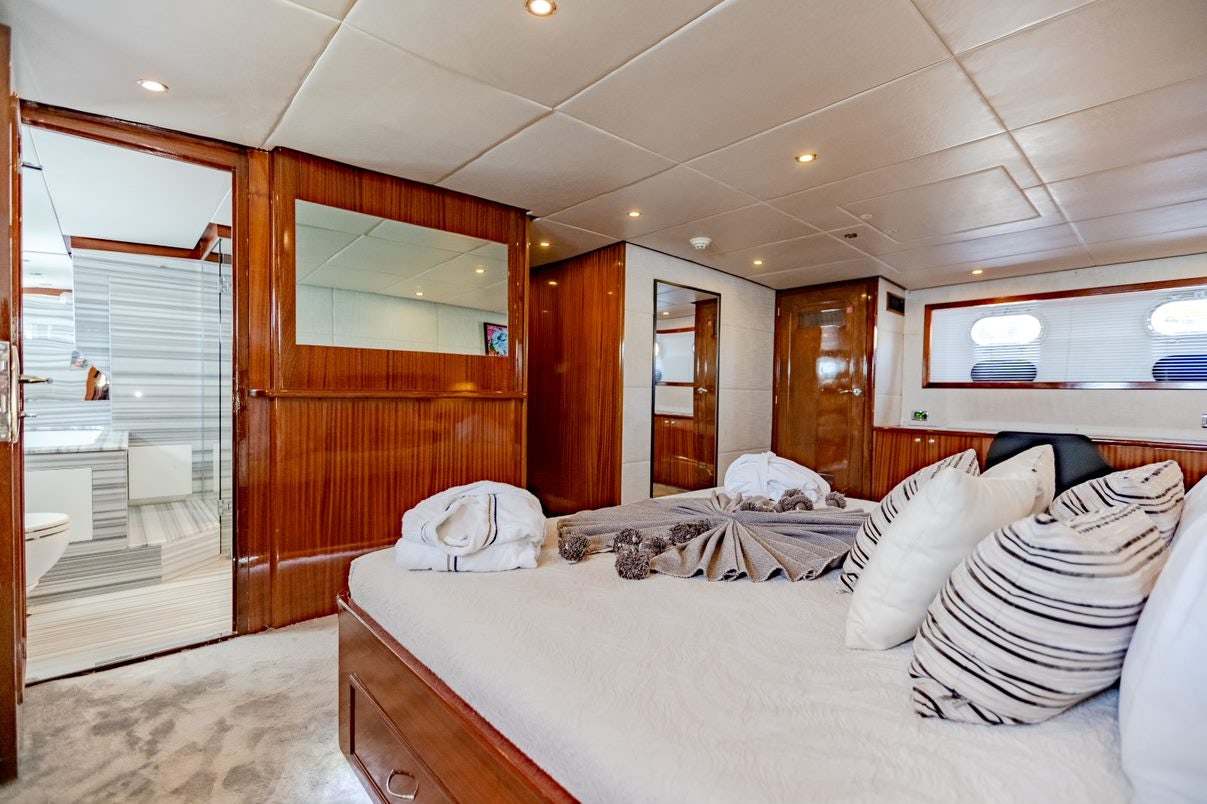 a bedroom with a bed and a wood door aboard ALHAMBRA Yacht for Charter