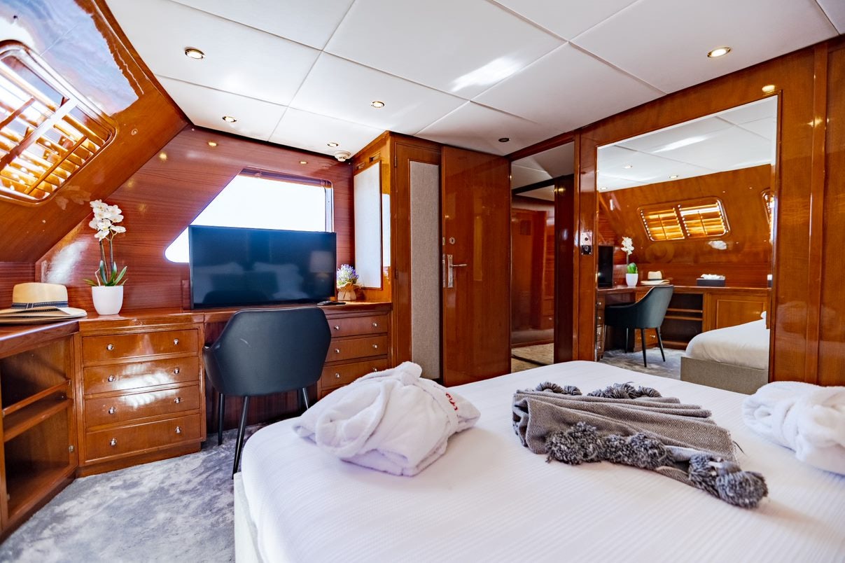 a bedroom with a bed and a desk aboard ALHAMBRA Yacht for Charter