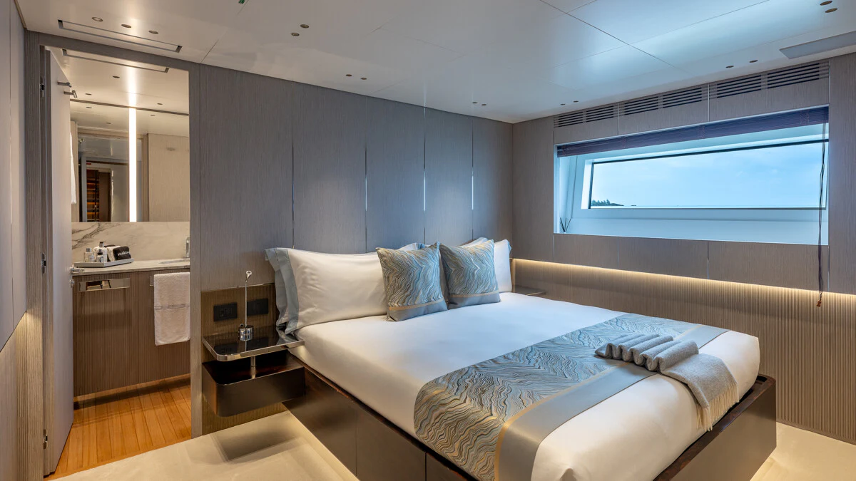 a bedroom with a bed and a window aboard ALPHA WAVES Yacht for Charter