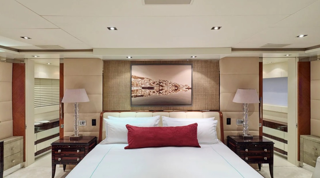 a bed with a red pillow aboard TIMBUKTU Yacht for Charter