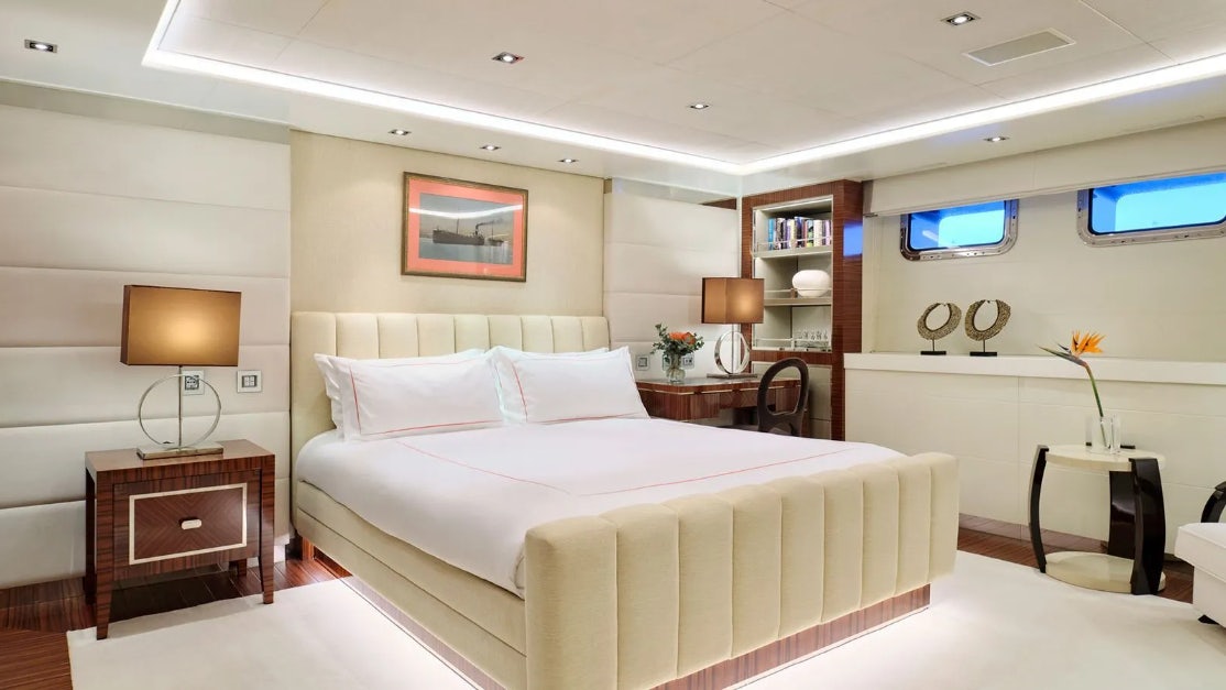 a room with a bed and a table aboard TIMBUKTU Yacht for Charter