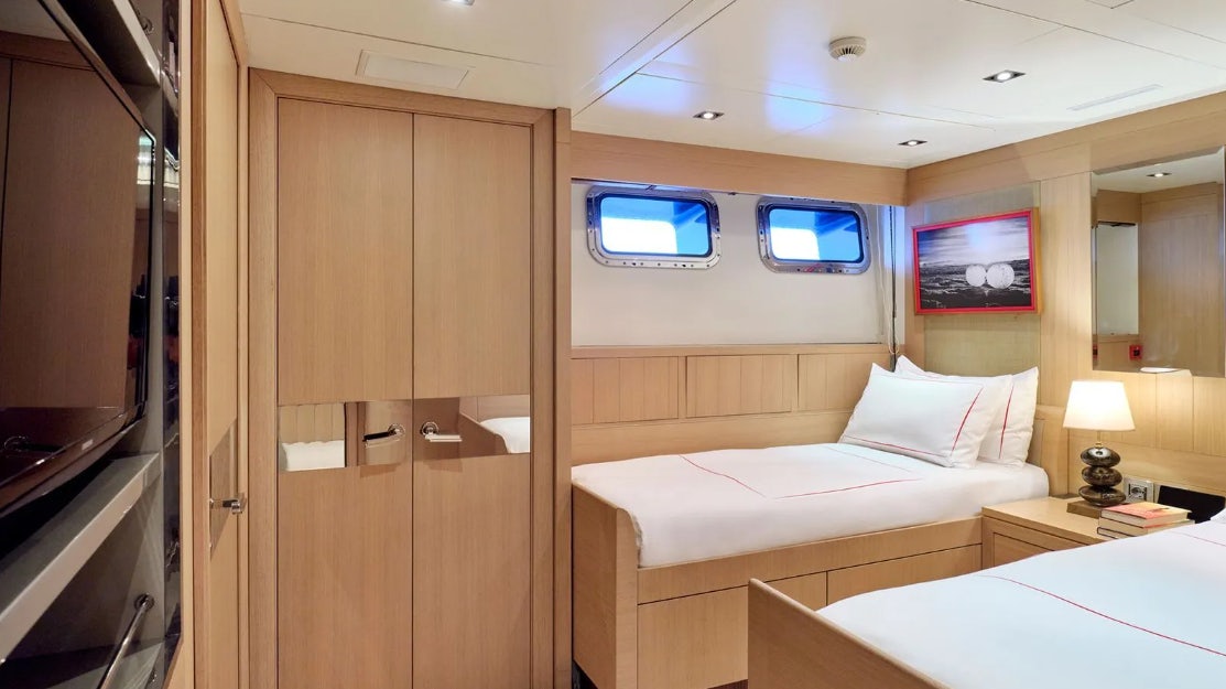 a room with a bed and a television aboard TIMBUKTU Yacht for Charter