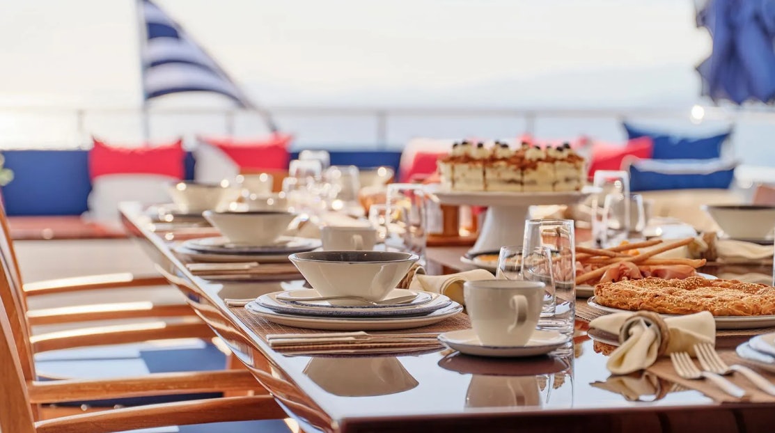 a table with plates and food on it aboard TIMBUKTU Yacht for Charter