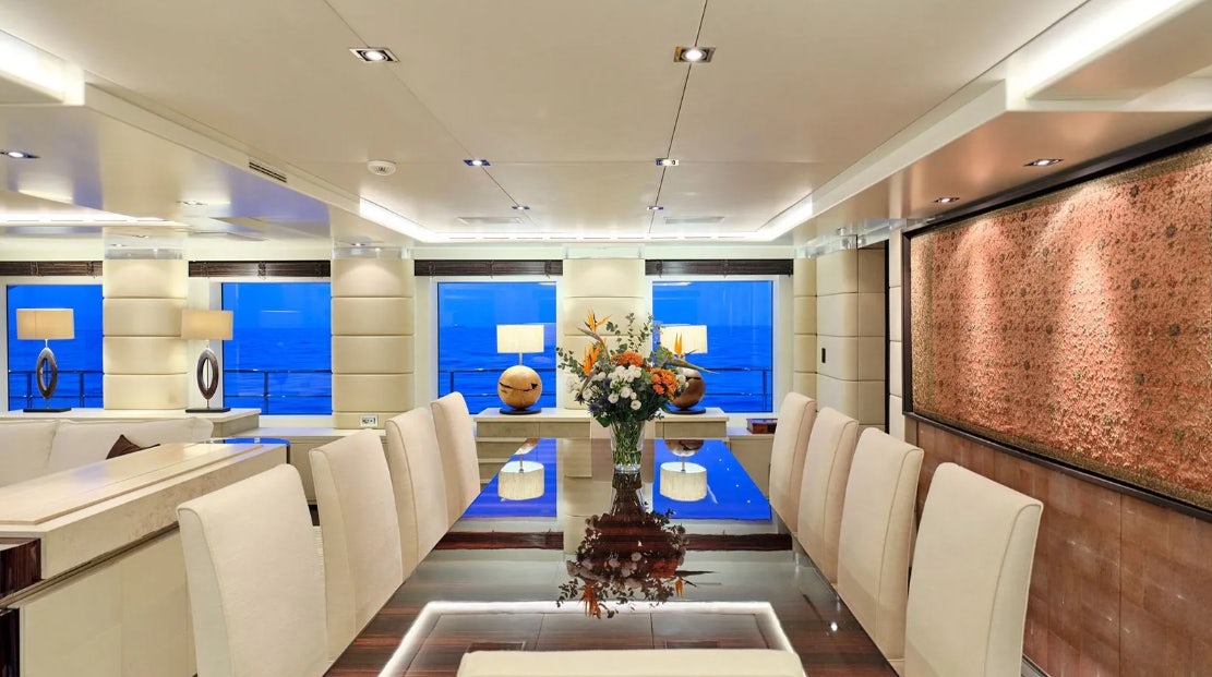 a room with white chairs and a vase with flowers in it aboard TIMBUKTU Yacht for Charter