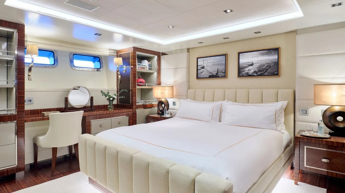 a bedroom with a bed and a desk aboard TIMBUKTU Yacht for Charter