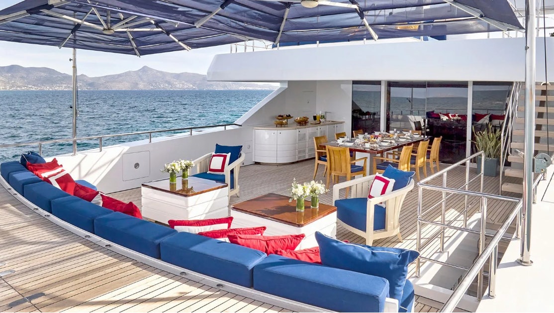 a boat with a table and chairs on the deck aboard TIMBUKTU Yacht for Charter