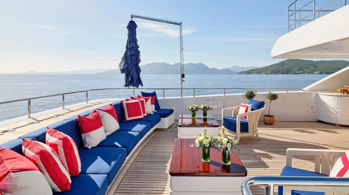 a deck with chairs and a table on it aboard TIMBUKTU Yacht for Charter