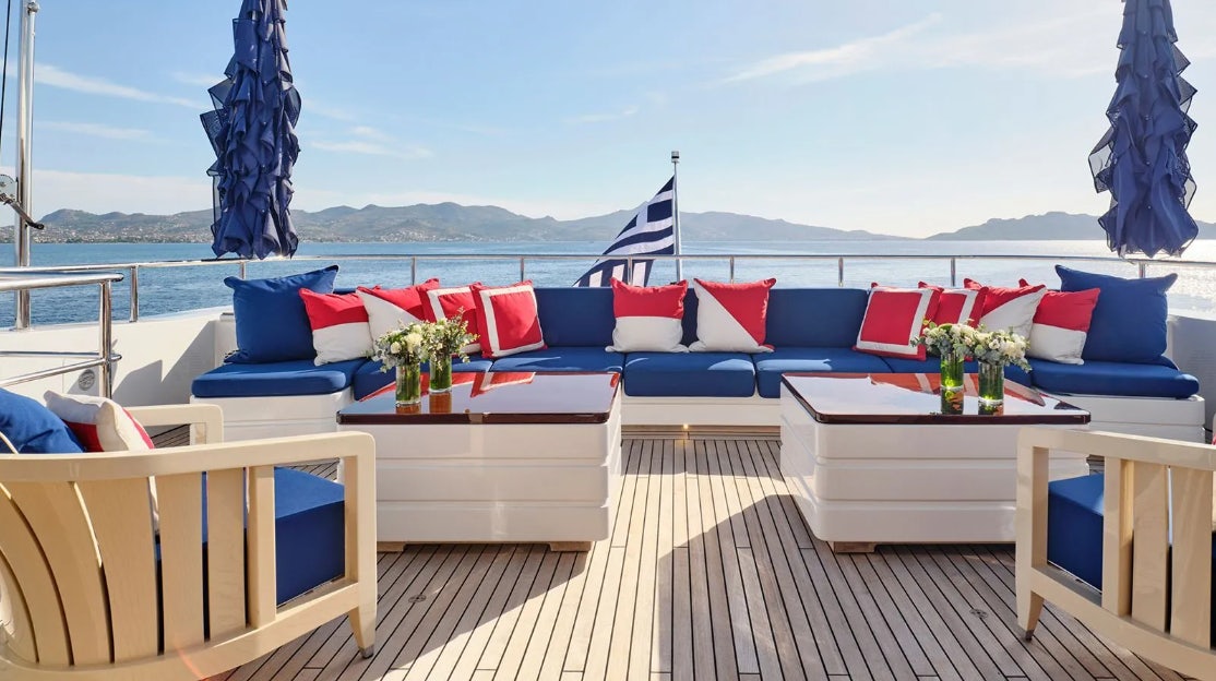 a deck with a table and chairs aboard TIMBUKTU Yacht for Charter
