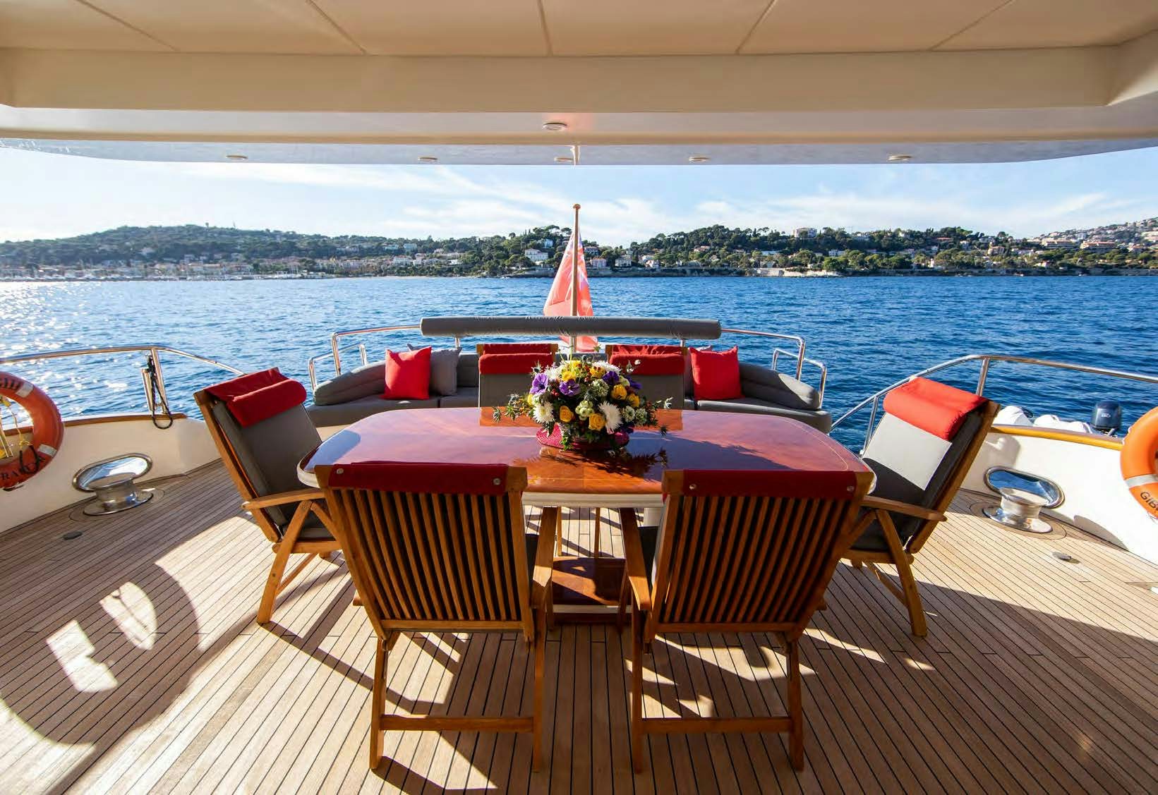 a table and chairs on a deck overlooking a body of water aboard VIKING III Yacht for Sale