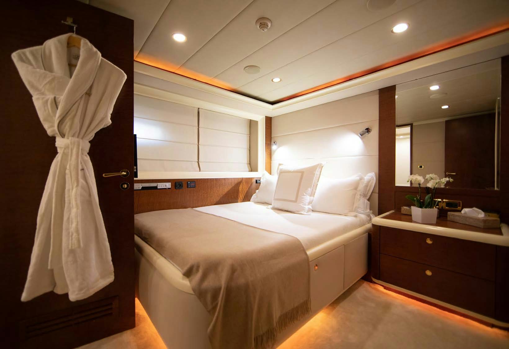 a bedroom with a bed and a white dress on the wall aboard VIKING III Yacht for Sale