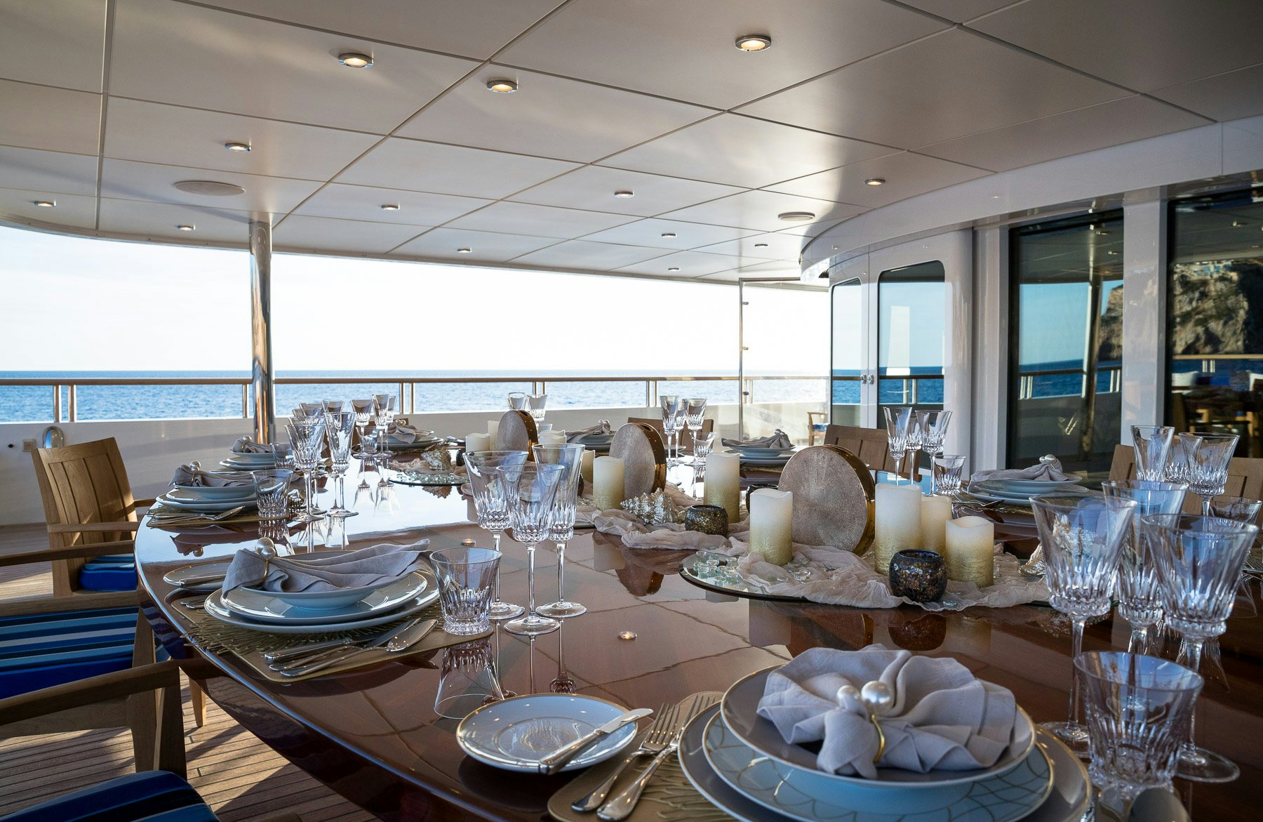 a large table with plates and glasses aboard BOADICEA Yacht for Charter